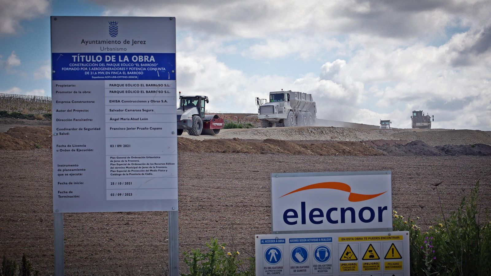 Cartel de la licencia municipal de obras junto a maquinaria que participa en la ejecución de las obras