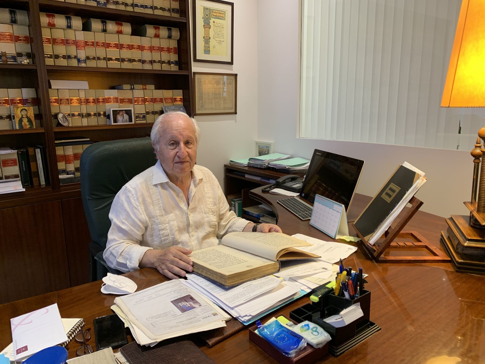 Manuel Portero con uno de los legajos antiguos que conserva en su despacho