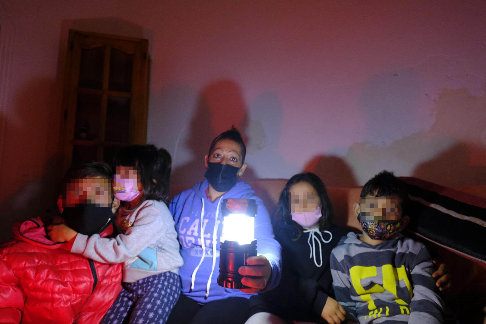 Lucía, con una vela que sirve de iluminación nocturna, en el sofá de su casa junto a sus cuatros hijos almerienses: José Javier, María del Rosario, Lucía y Jesús.