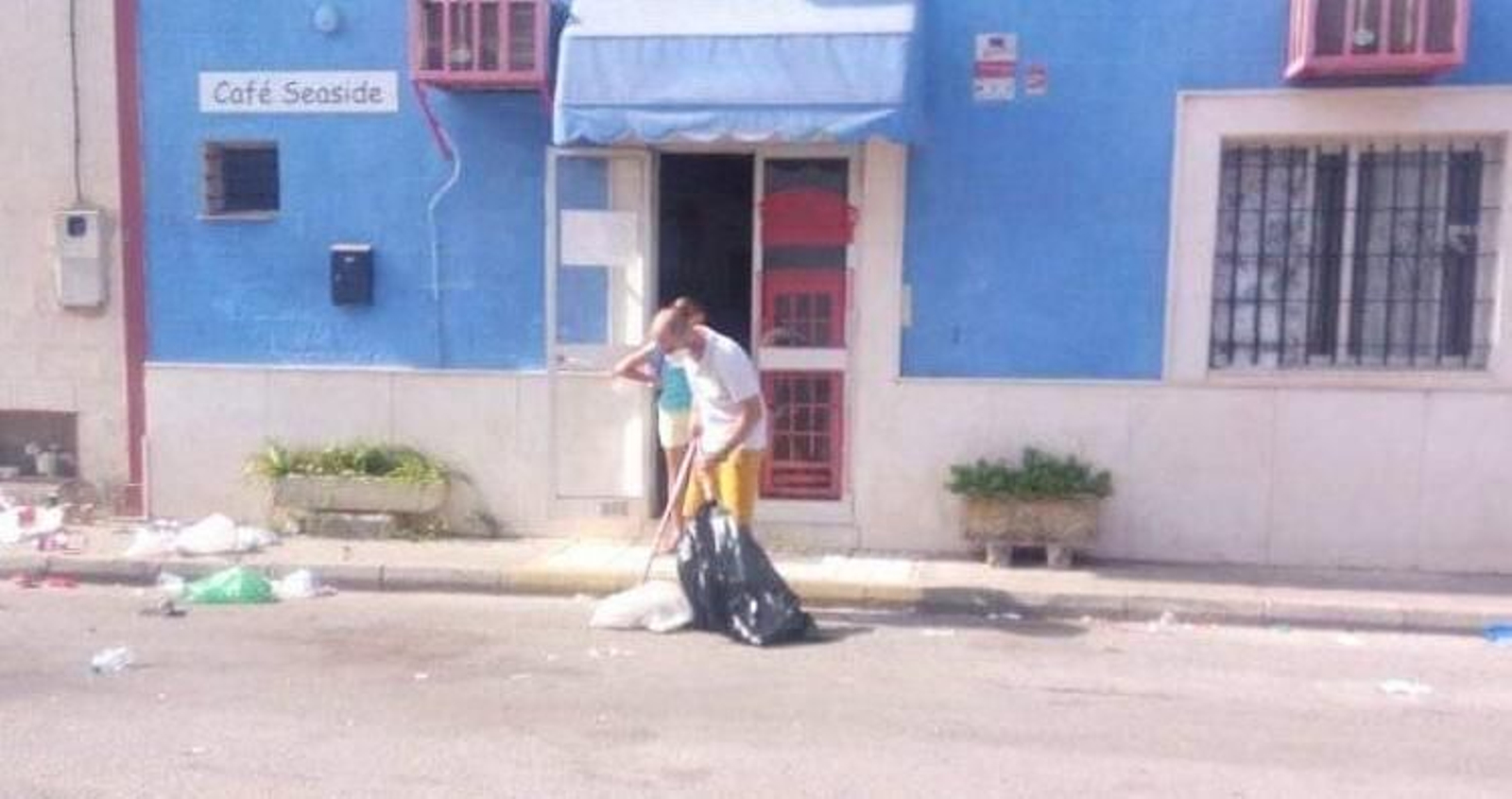 Trabajadores de una de las empresas, limpiando los restos del botellón.