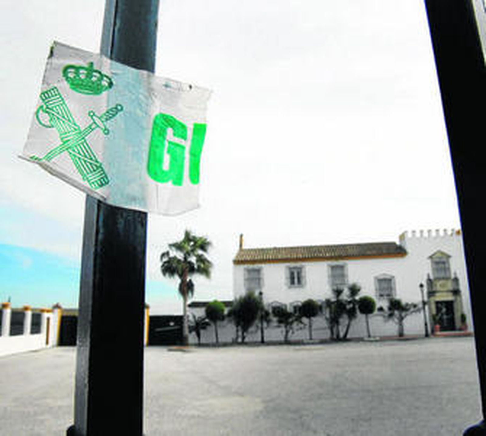 Valla de acceso al hotel club La Hacienda, en El Puerto, con un resto del precinto de la Guardia Civil.