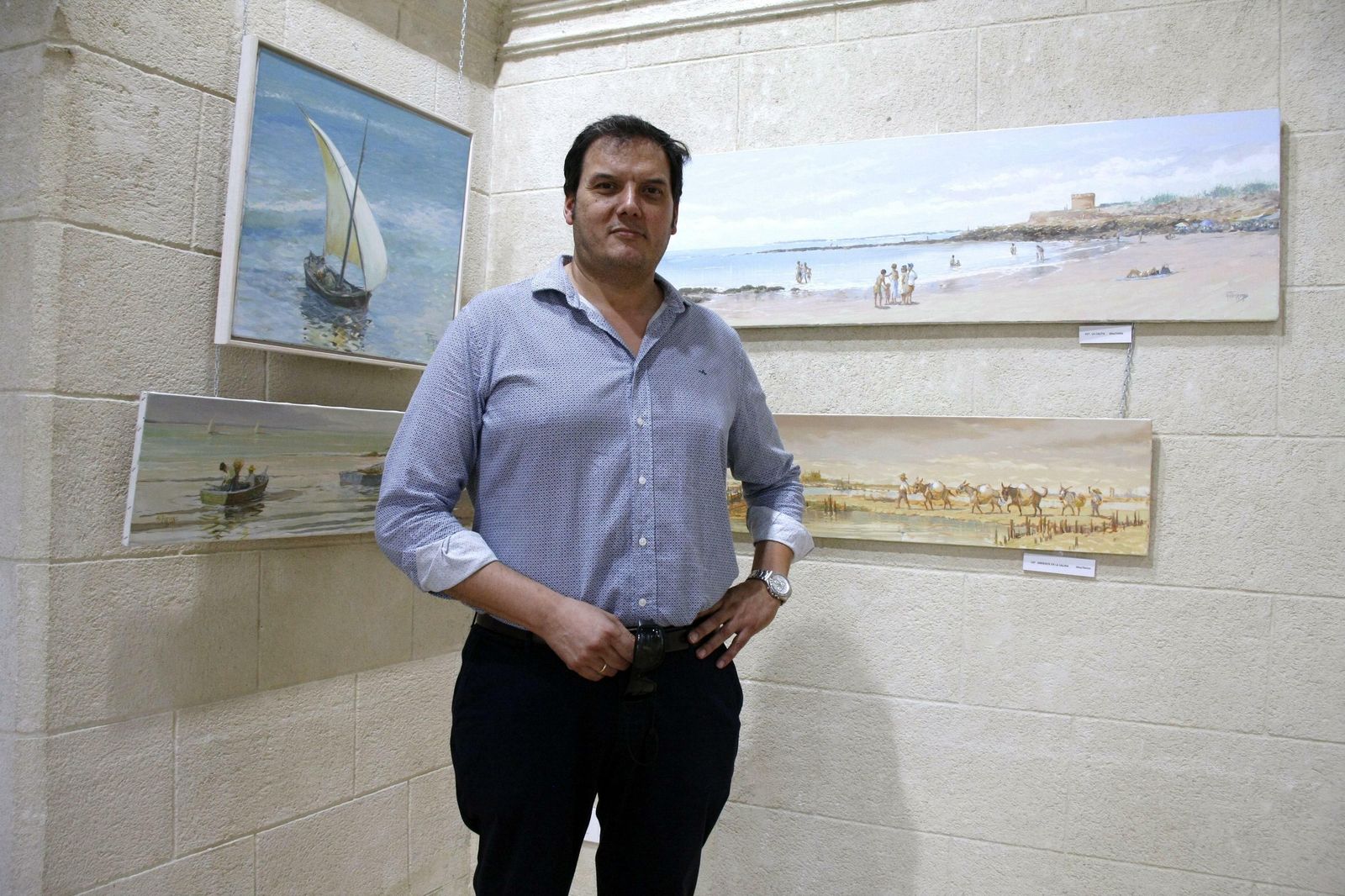 Adrián Ferreras, junto a algunos de los cuadros que expone en la muestra.