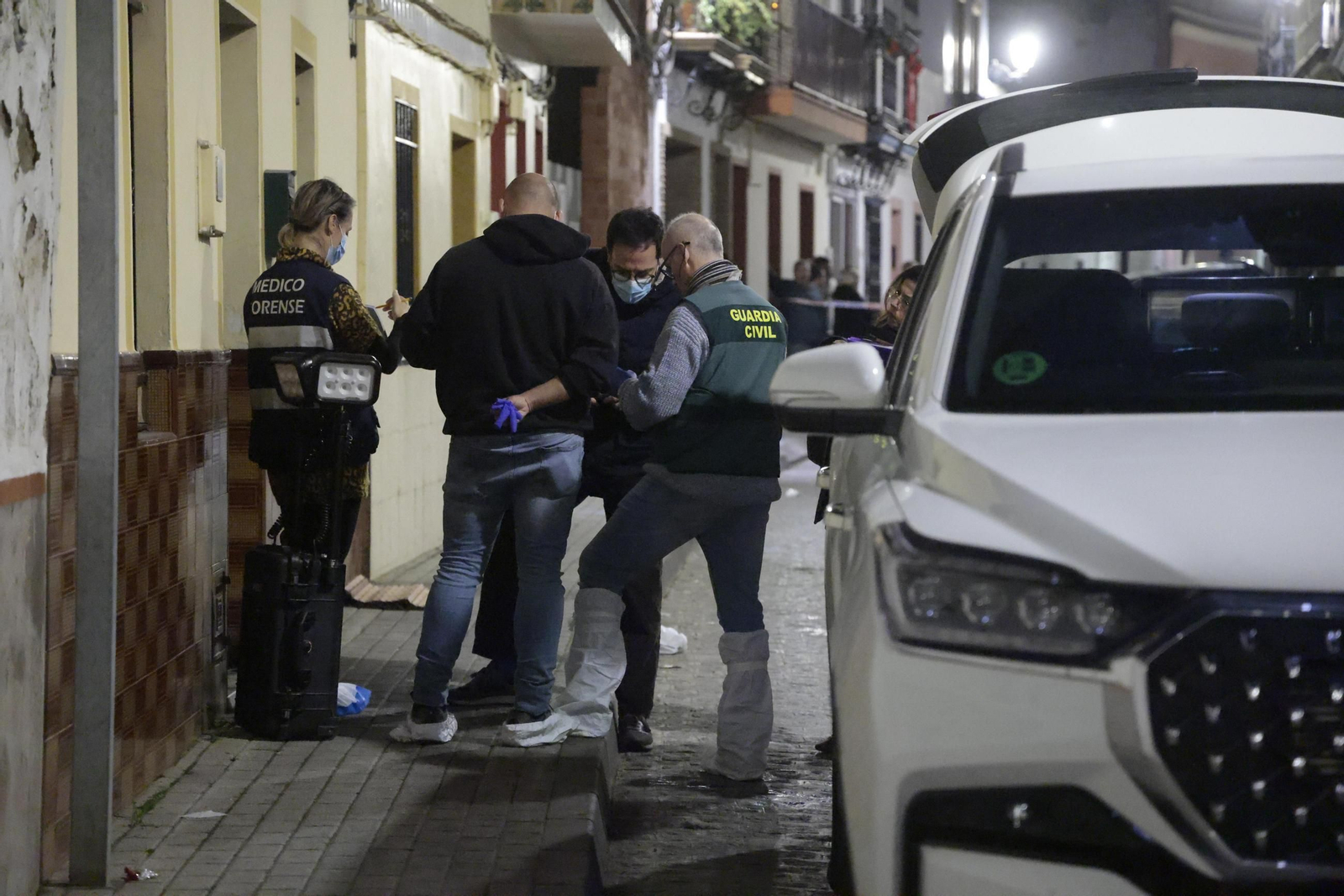 Guardias civiles y miembros de la comisión judicial, en la puerta de la casa donde se cometió el crimen, la noche del sábado.