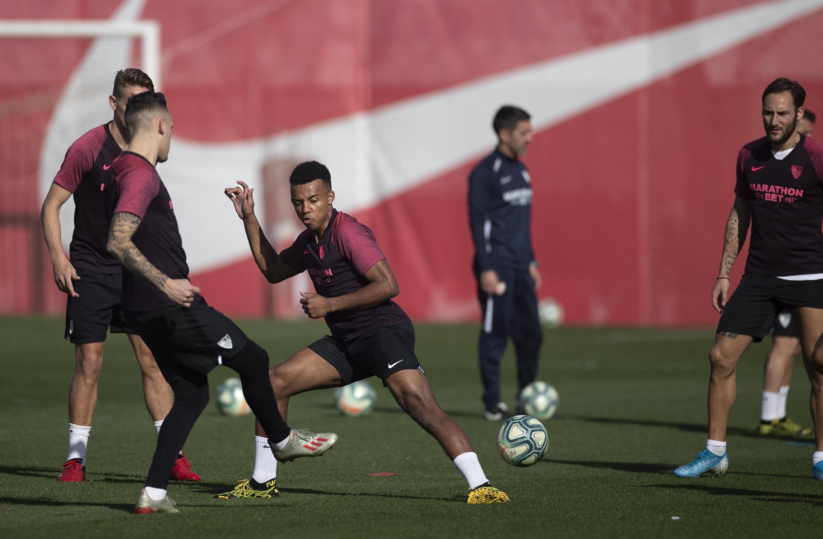 Koundé intenta tapar el pase de Ocampos a Gudelj en un rondo.