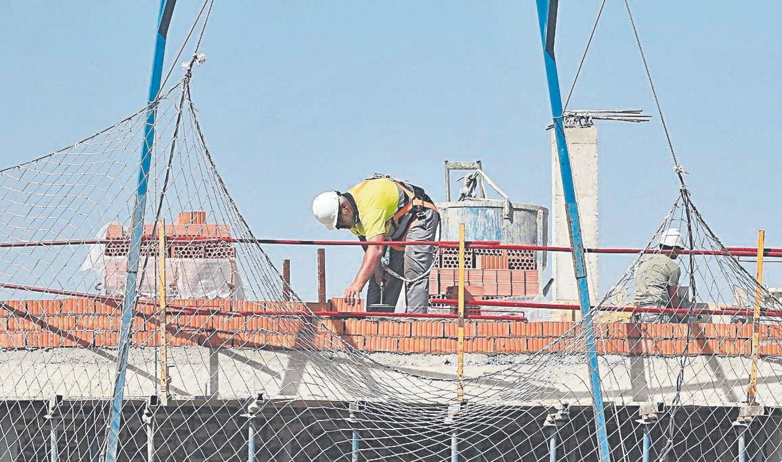 Un operario trabaja en una promoción inmobiliaria. Un operario trabaja en una promoción inmobiliaria.