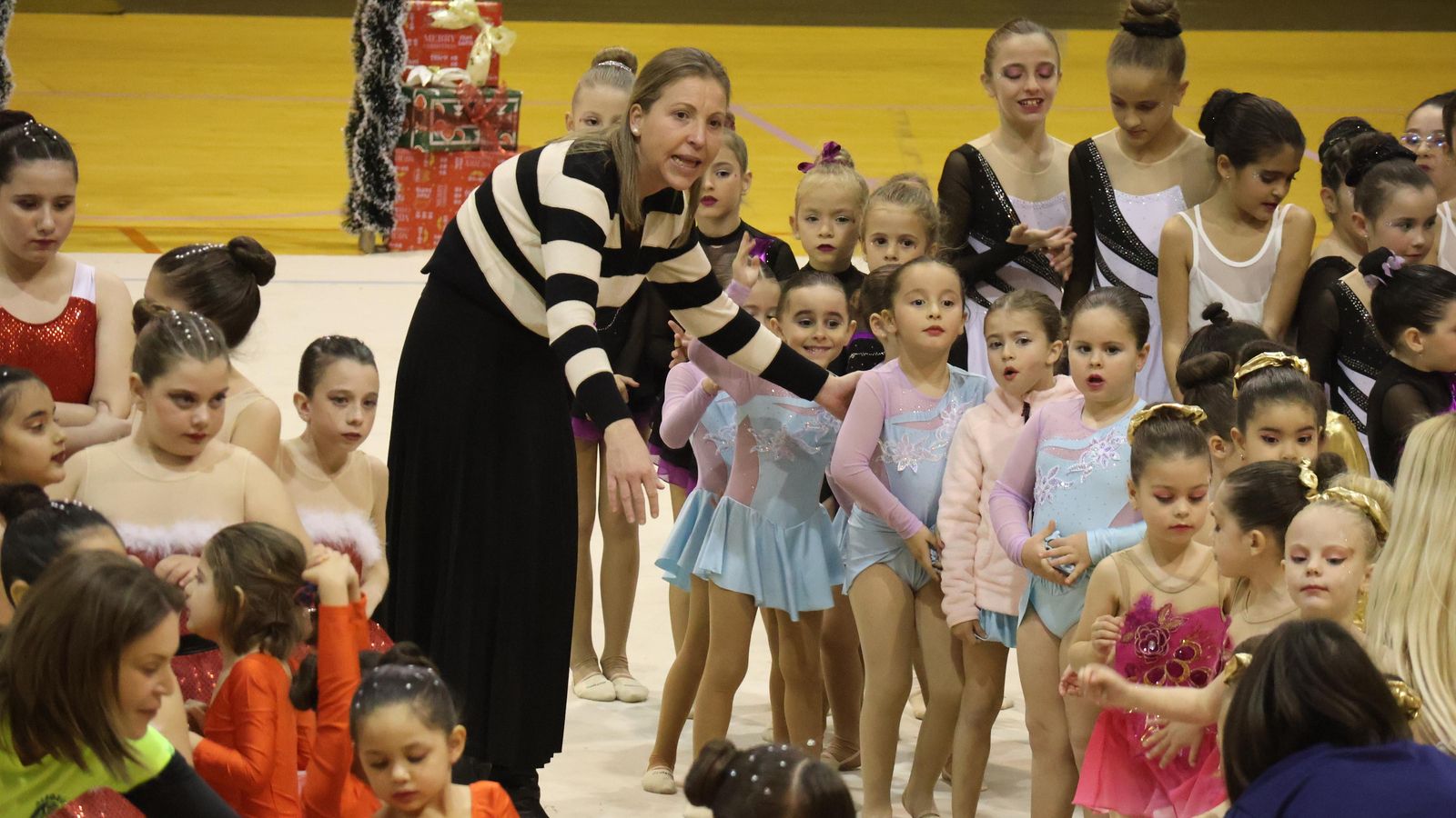 La edil de Deportes atiende a un grupo participantes que espera sobre el tapiz.