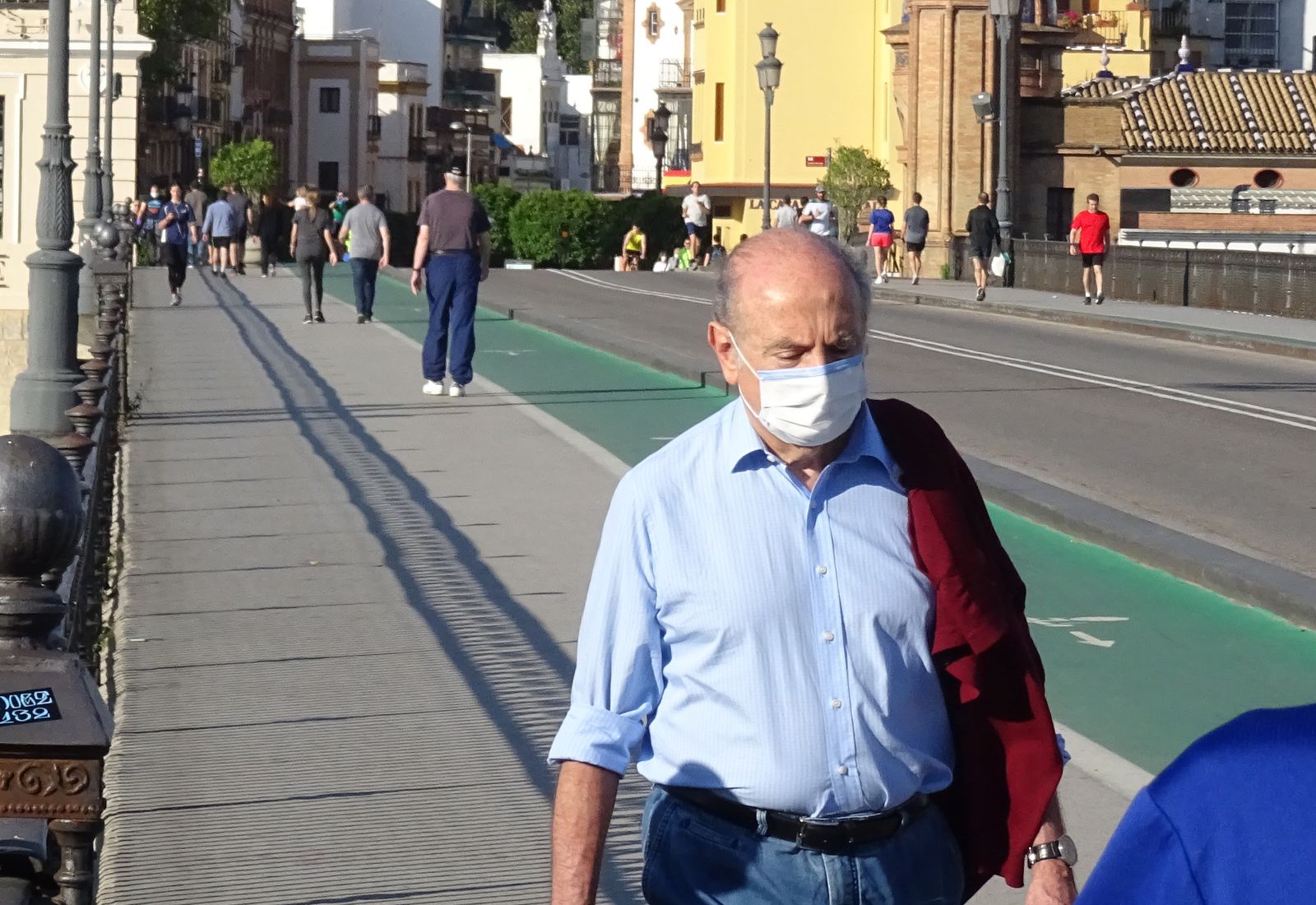 Varios viandantes cruzan el puente de Triana este fin de semana.