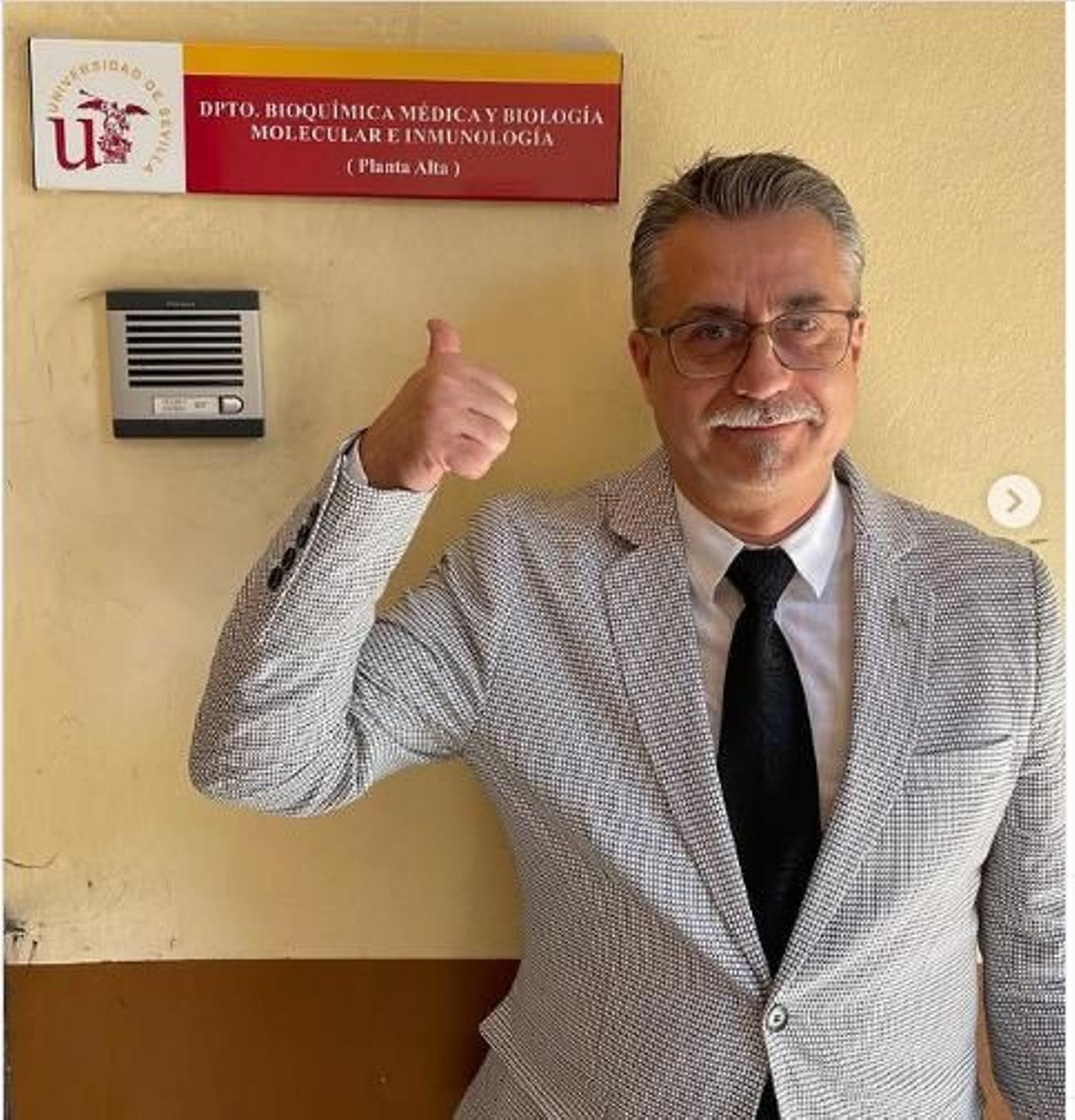 El prestigioso inmunólogo Alfredo Corell señala el cartel del departamento de la US en el que es nuevo catedrático.