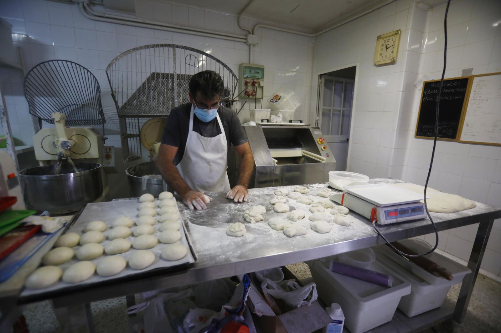 Un trabajador de una panadería de Córdoba le da forma a distintas piezas de pan.