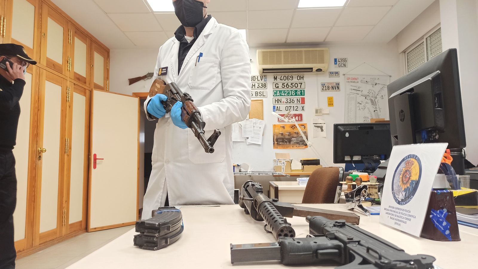 Un agente de la Policía Científica muestra un kalashnikov intervenido.