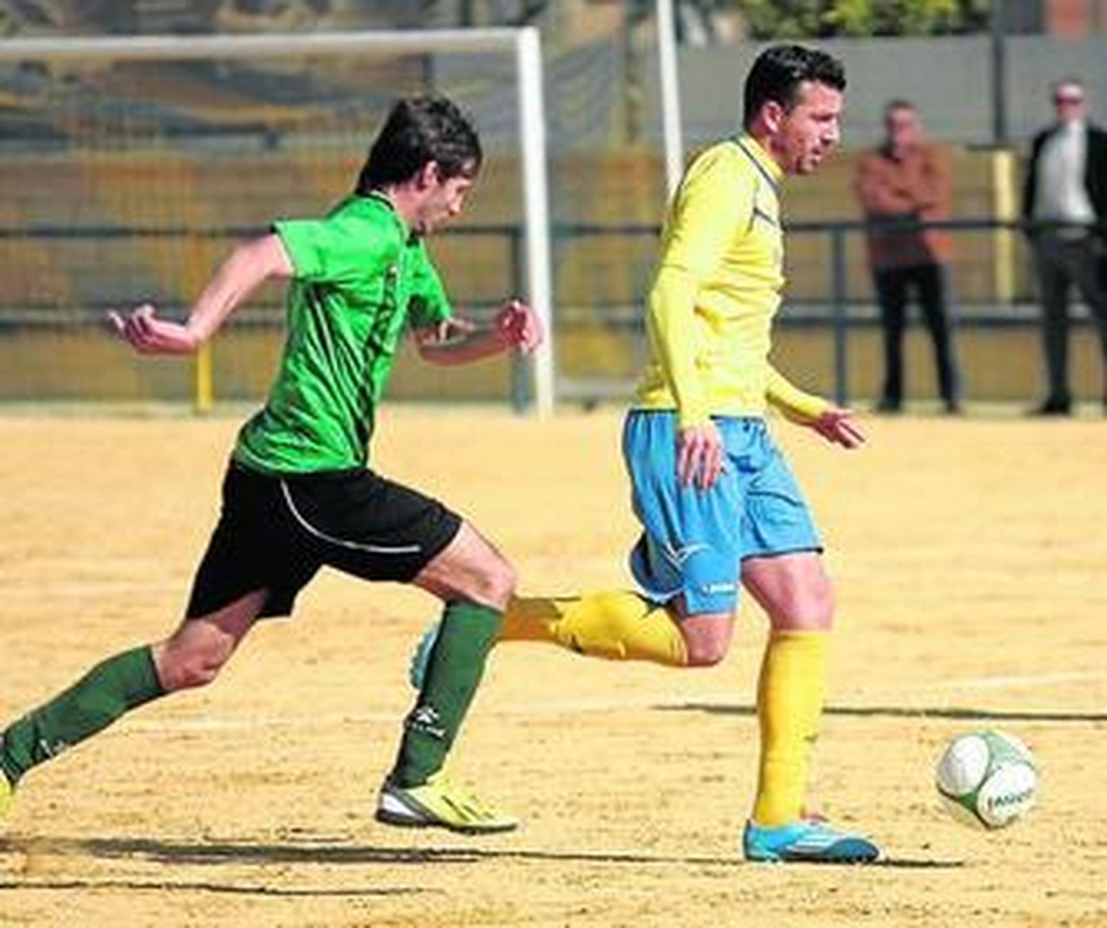 El futbolista de la Rociera Villalón es perseguido por un jugador del cuadro de La Carlota.