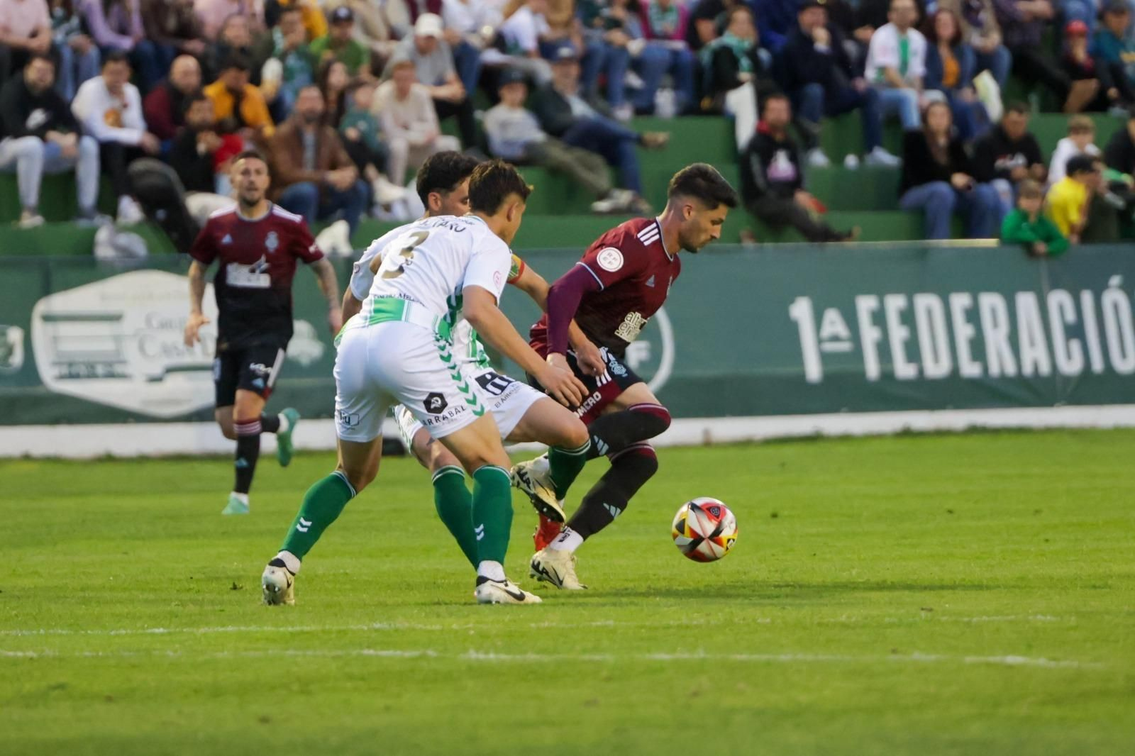 Caye Quintana controla el balón ante la presión de dos jugadores del Antequera.