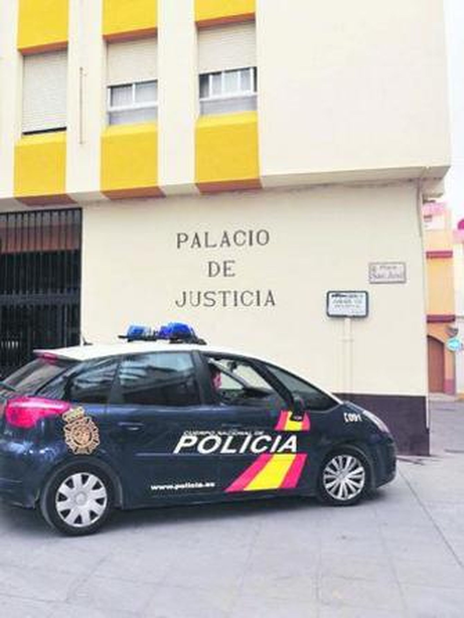 Un vehículo de la Policía Nacional, a la entrada del Palacio de Justicia de San Fernando.