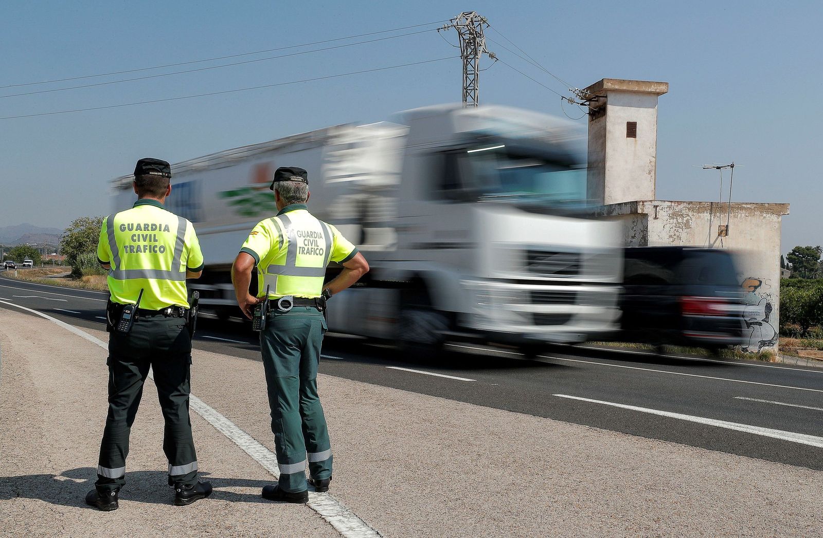 Dos agentes de la Guardia Civil de Tráfico, a pie de carretera.