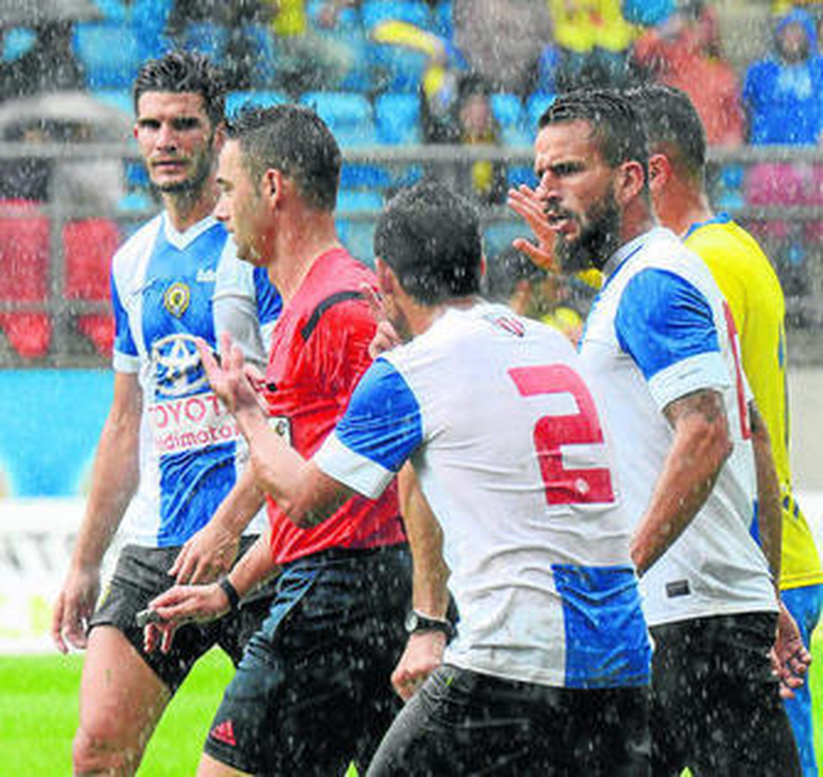 Futbolistas del Hércules rodean al árbitro tras pitar el penalti.