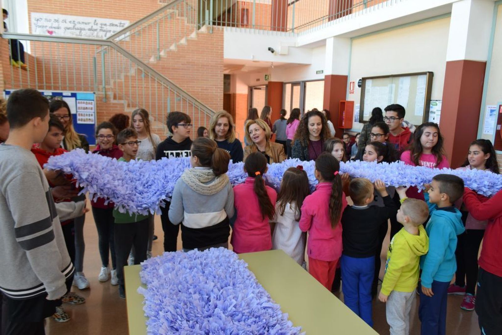 1. Un grupo de chavales preparan el lazo lila. 2. Traslado de una de las partes a otro centro educativo. 3 y 4. El alcalde Antonio Bonilla ha visitado algunos de los colegios para ver como iba la elaboración,