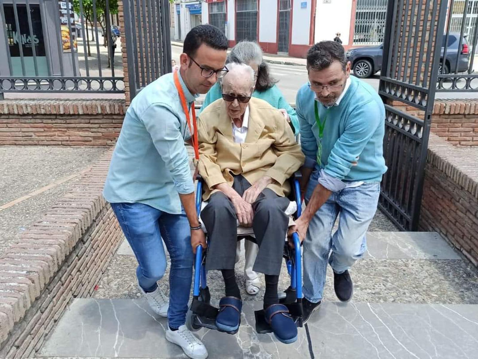 Una persona es ayudada por otras tres para ejercer su derecho al voto.