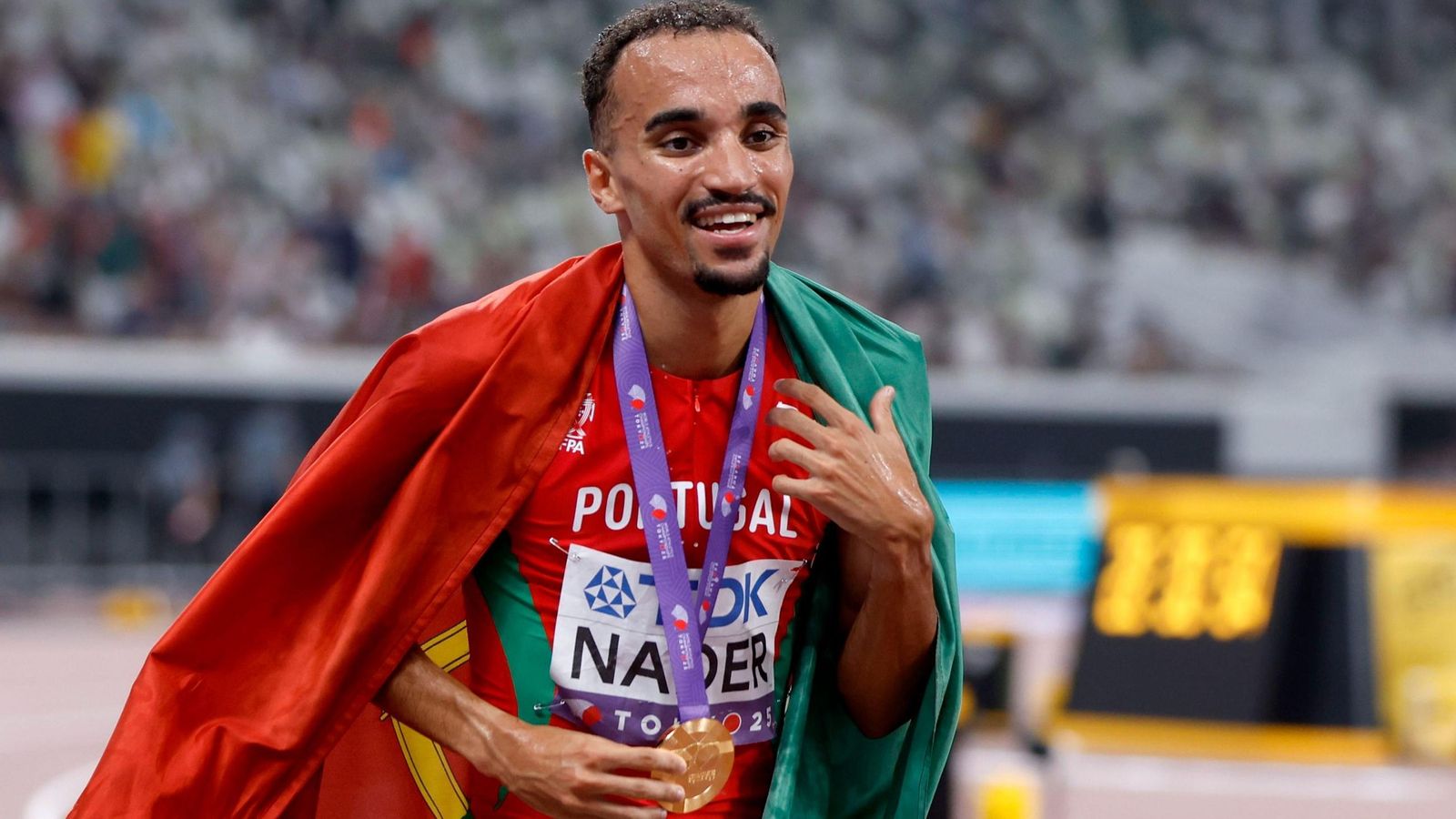 Nader celebra con la medalla de oro y la bandera de Portugal