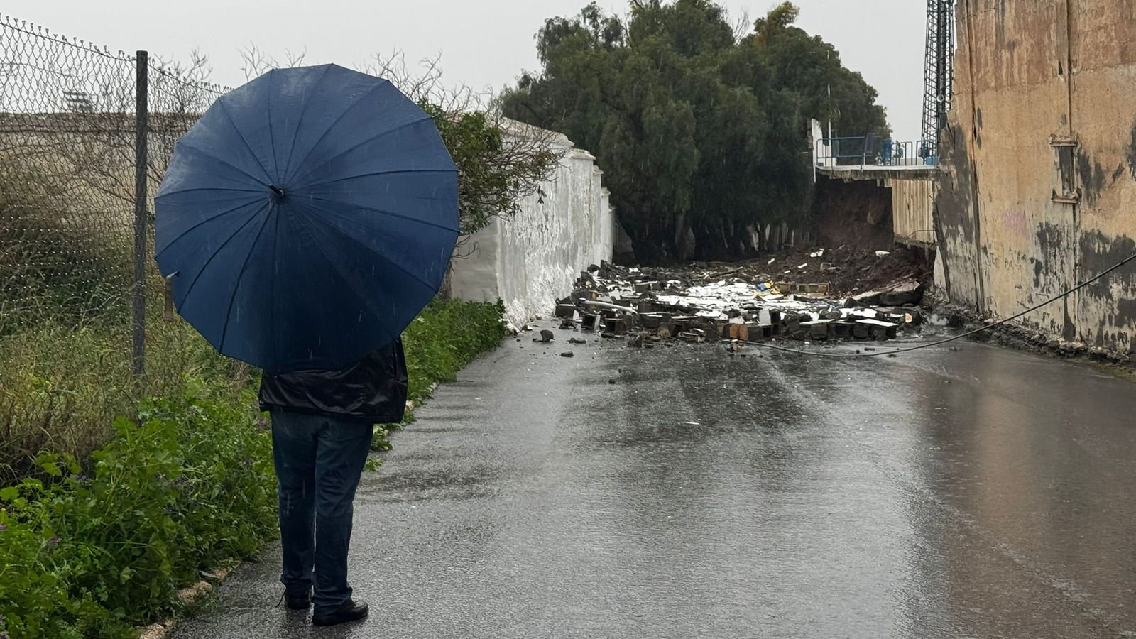Una persona observa el muro caído