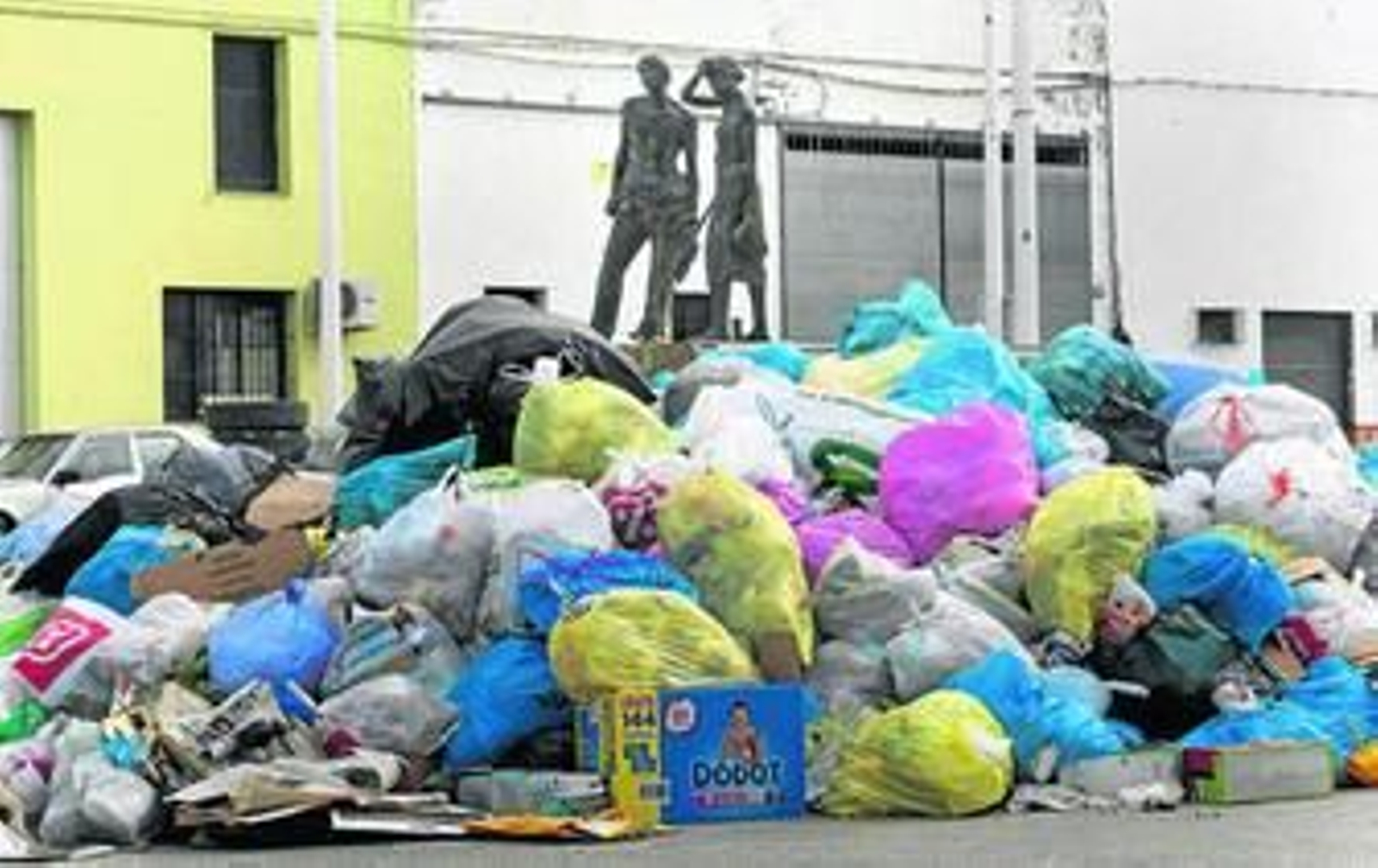 Montañas de basura ante la escultura dedicada a los jornaleros de El Coronil, situada a las afueras del pueblo.