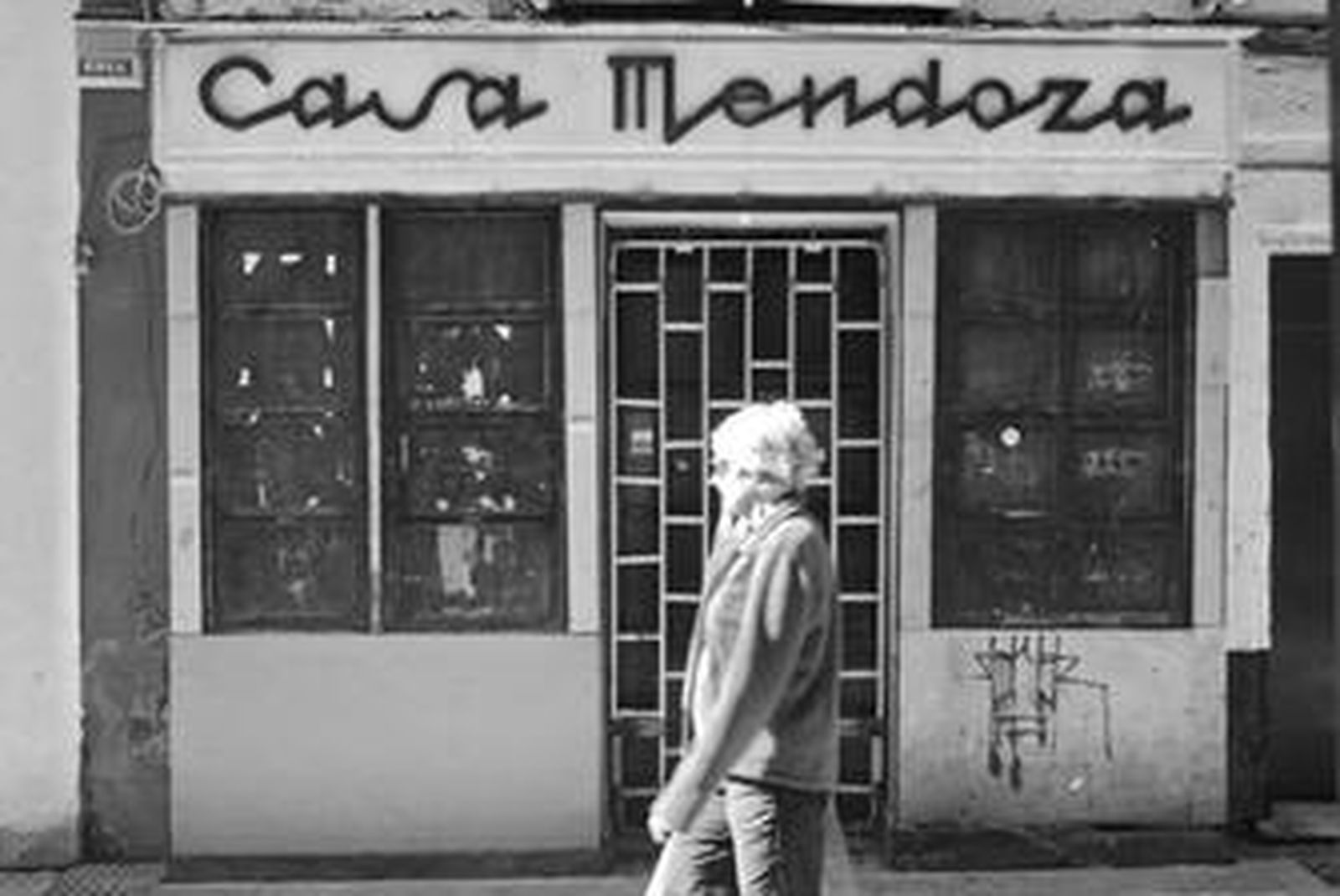 Una mujer pasa delante de un comercio en la calle Sacramento que lleva cerrado desde hace mucho tiempo y que está en un mal estado de conservación.
