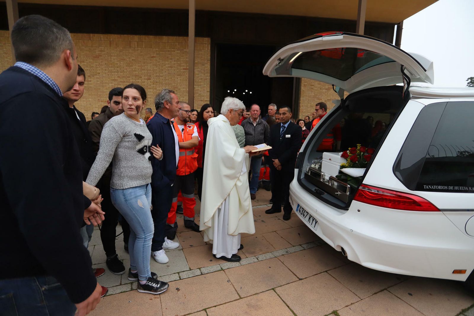 El padre Bernal diciendo unas palabras ante el ataúd del bebé de La Hispanidad, mientras Patricia sostiene por el brazo al abuelo del niño, Paco Palma.