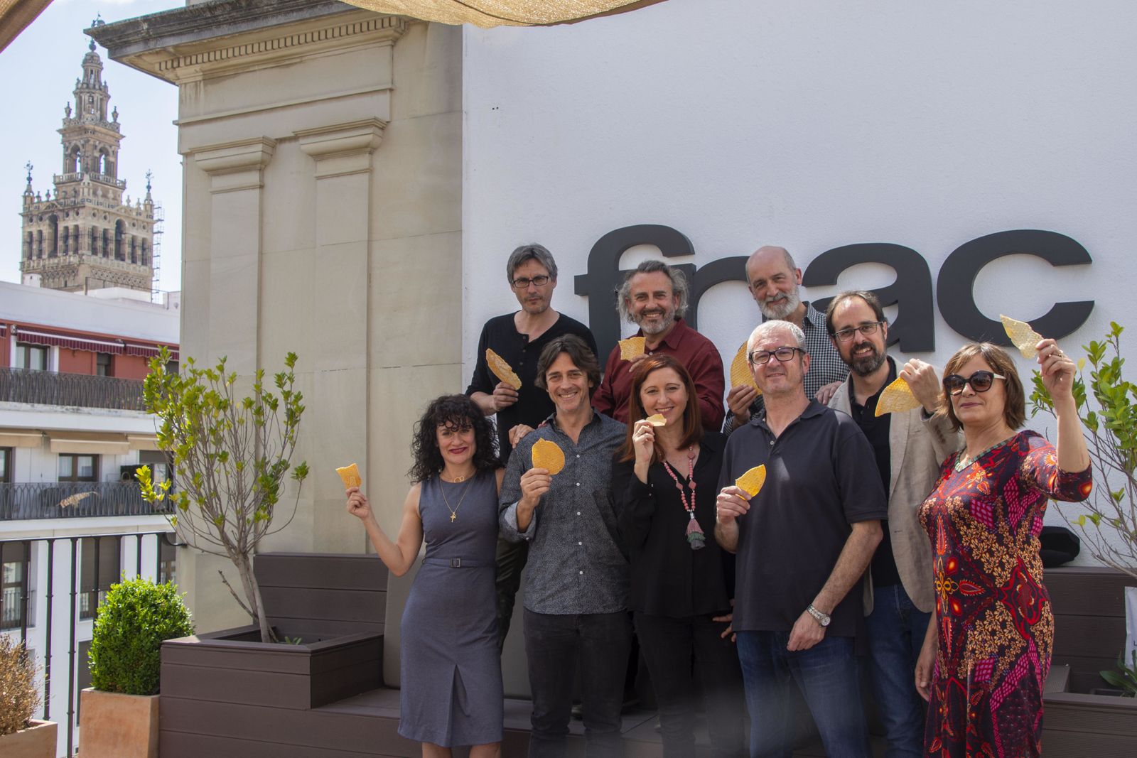 Con la Giralda de fondo, arriba, de izquierda a derecha, José María Peña, Manuel Monteagudo y Antonio Campos. Debajo, de izquierda a derecha, Paqui Montoya, Moncho Sánchez-Biedma, Ana Graciani, Ángel López Navas, Elías Sevillano y Sofía Aguilar, ayer en el FNAC con una regañá./ Gabriel Mármol Torres