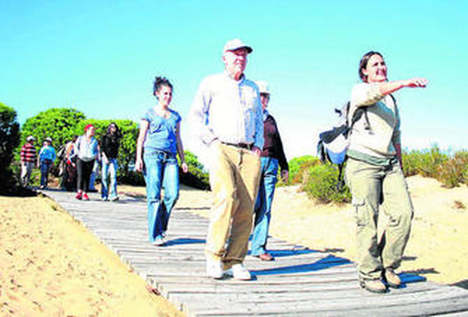 Un grupo de personas camina por un sendero natural.