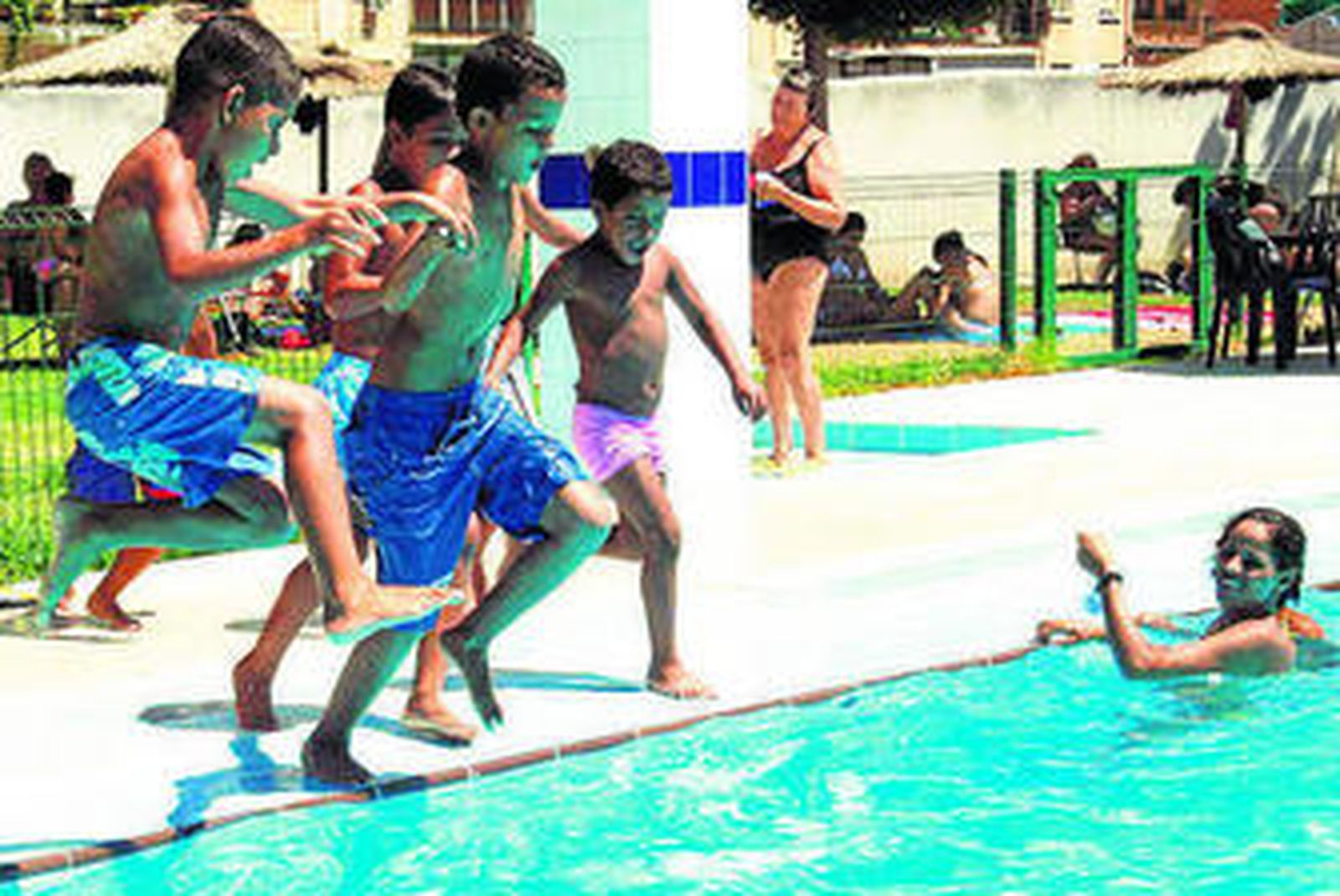 Varios niños se disponen a bañarse en una piscina.