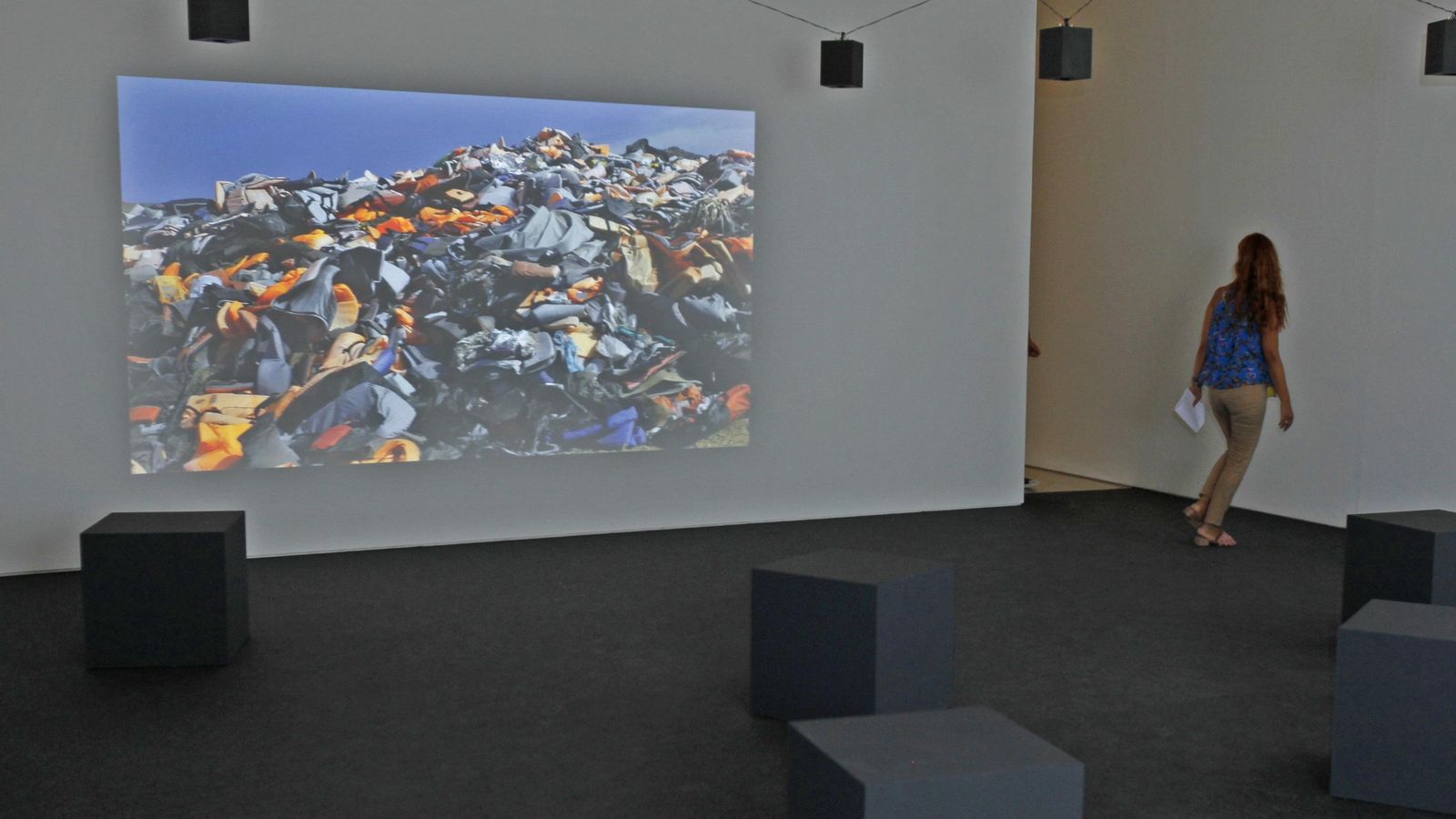 Una mujer pasa ante una de las las pantallas que forman parte de la instalación 'Crossings'.