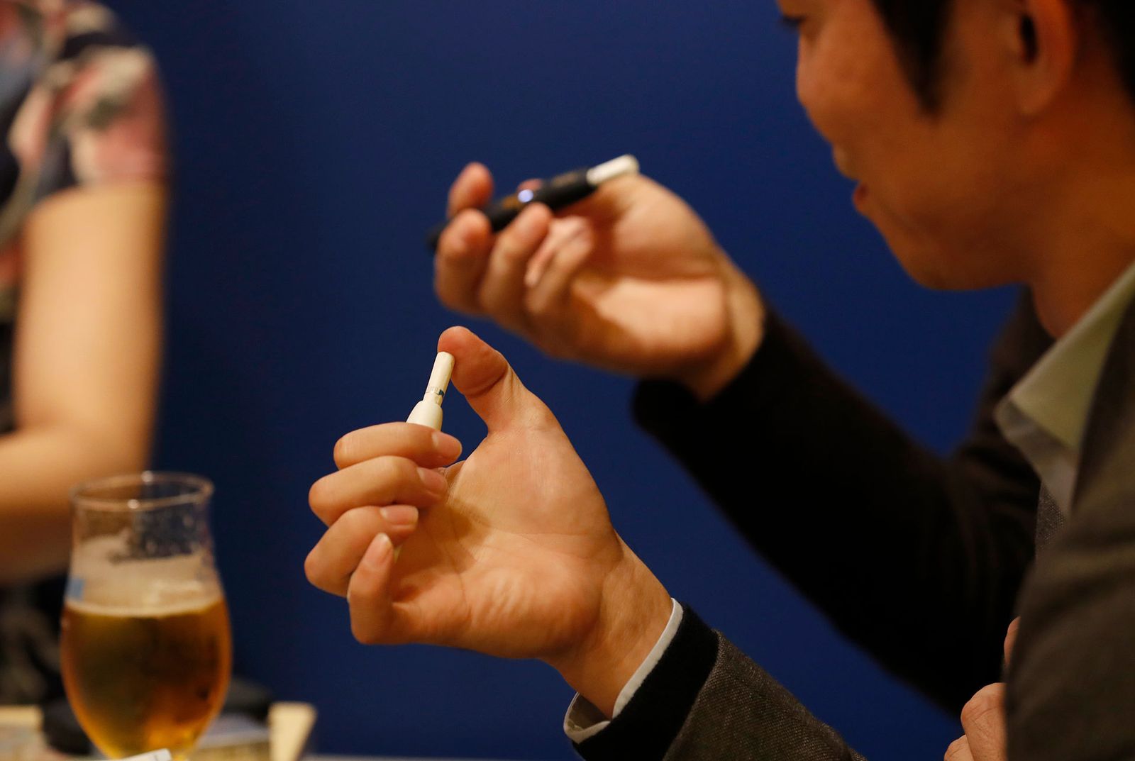 Un hombre fuma con uno de los dispositivos iQOS en un restaurante en Tokio.