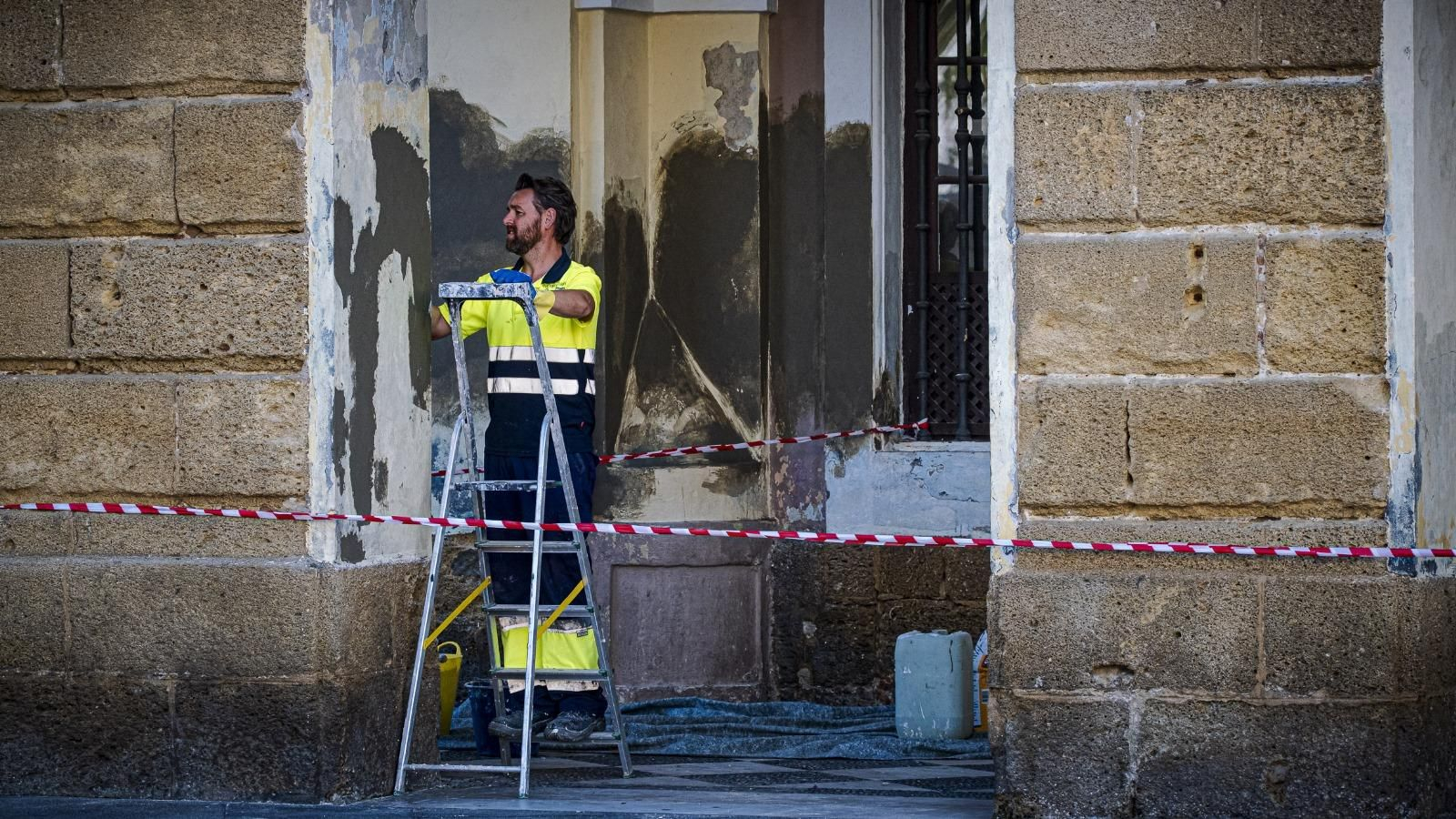 Un operario trabajando en los soportales del Ayuntamiento de Cádiz.