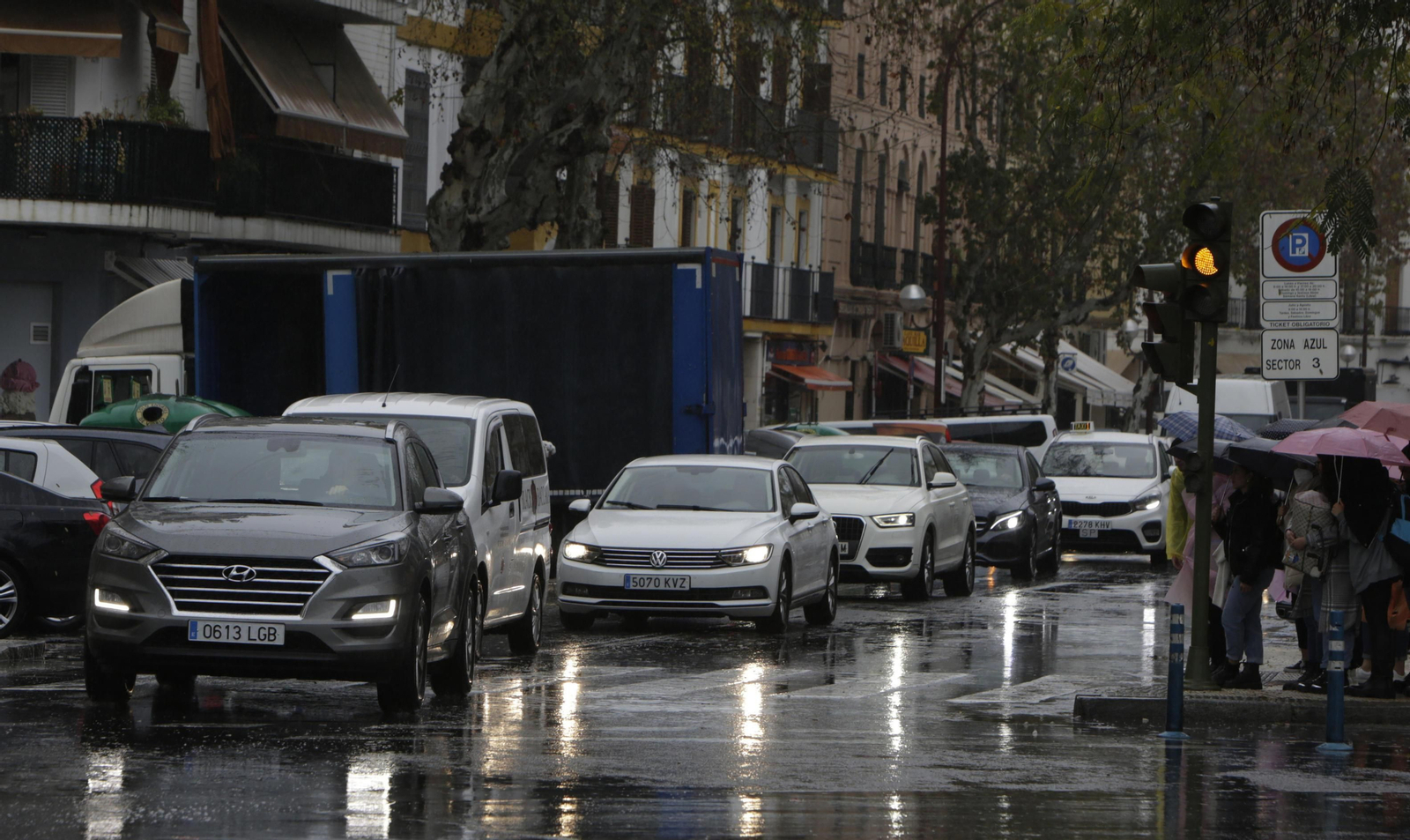 Varios vehículos circulan bajo la lluvia por la céntrica calle Adriano.