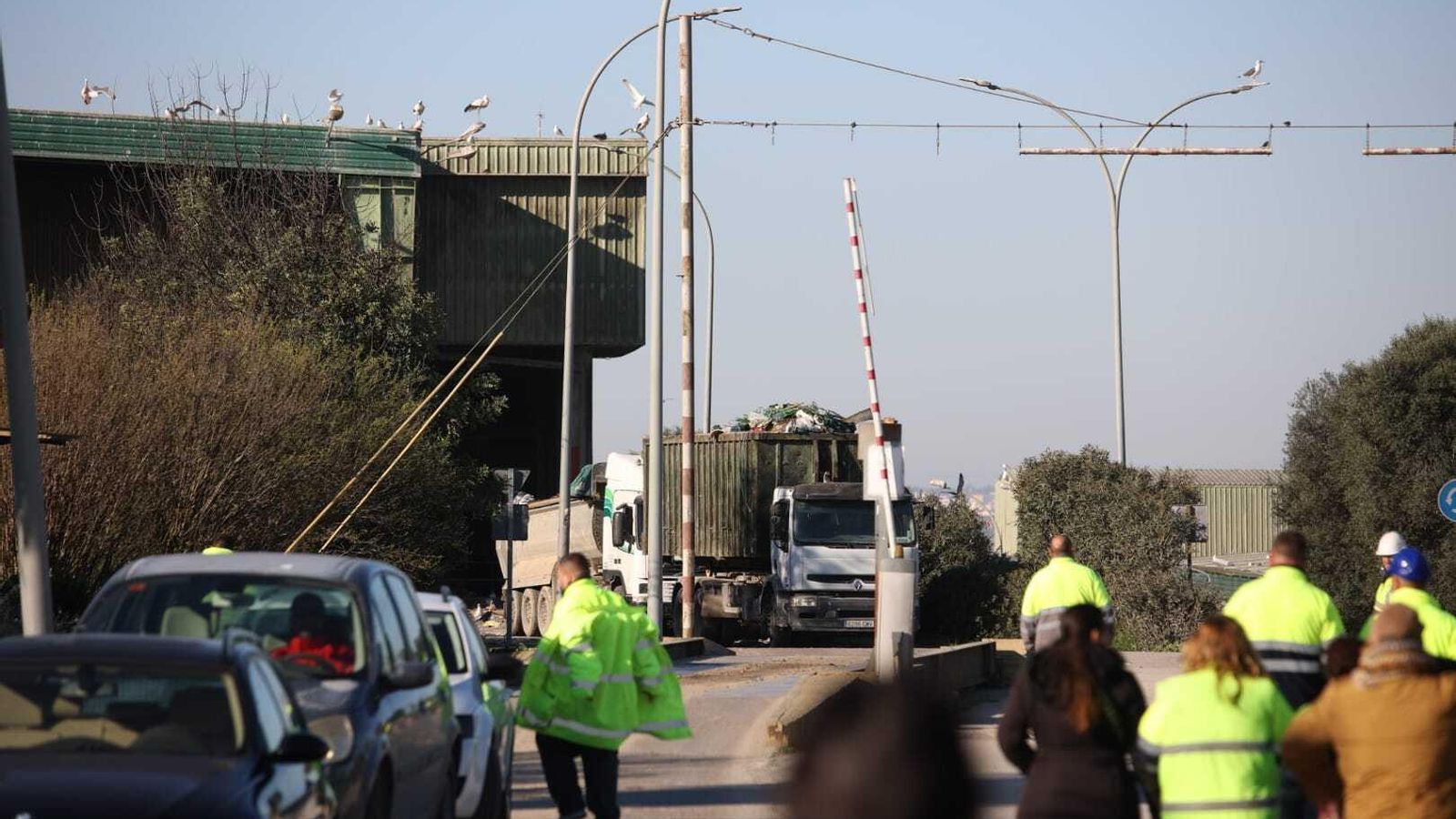 Un camión de residuos en las instalaciones de Las Calandrias, con los trabajadores concentrados a las puertas.