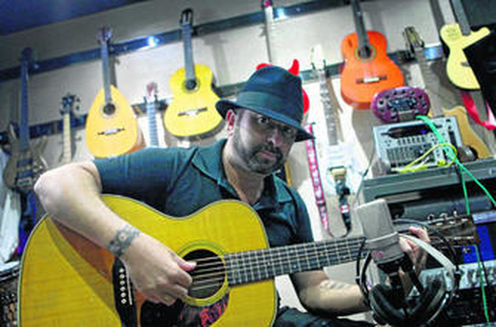 El artista gaditano José Luis Figuereo, 'El Barrio', toca la guitarra en su estudio.
