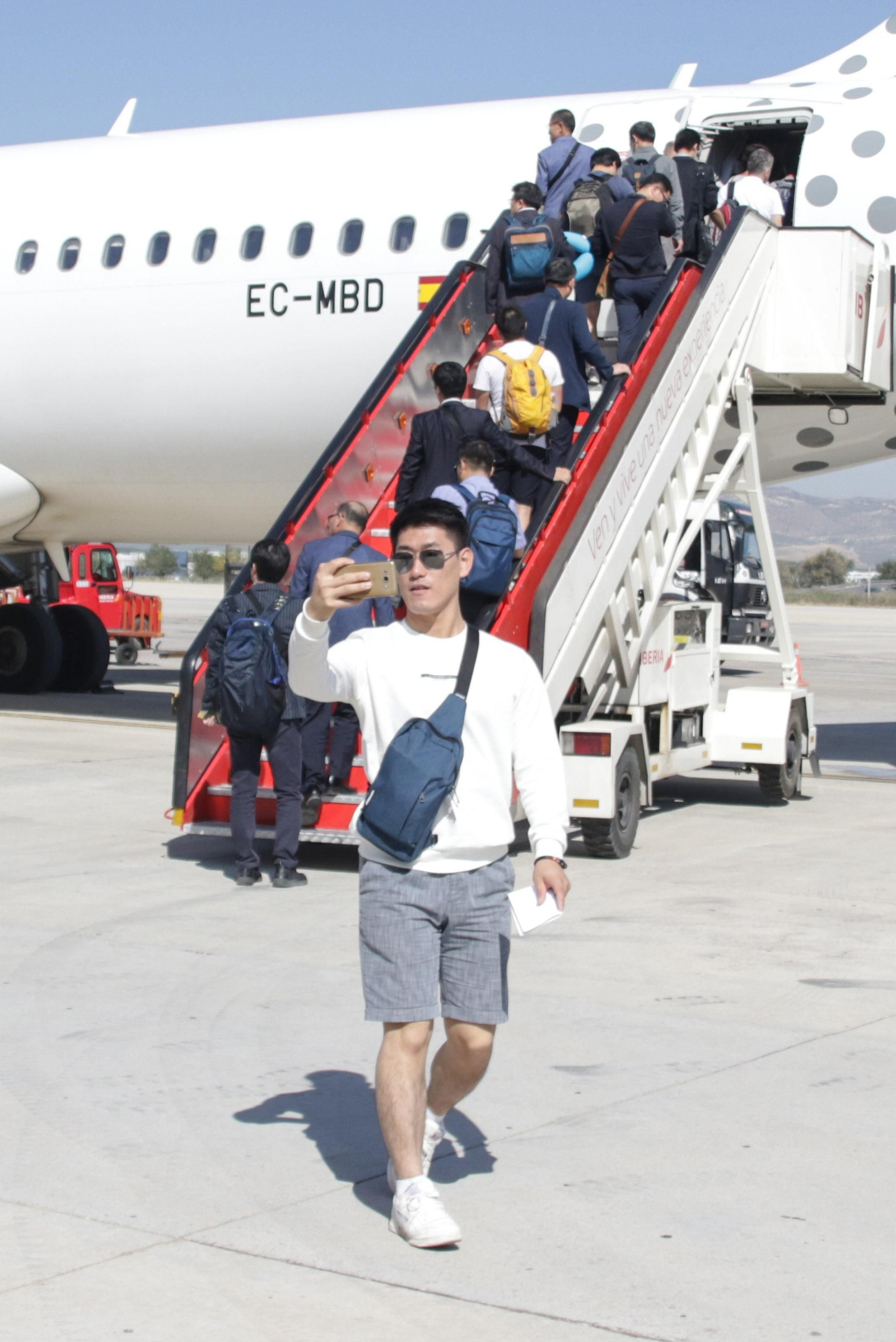 Un turista toma un selfie antes de subir a su avión