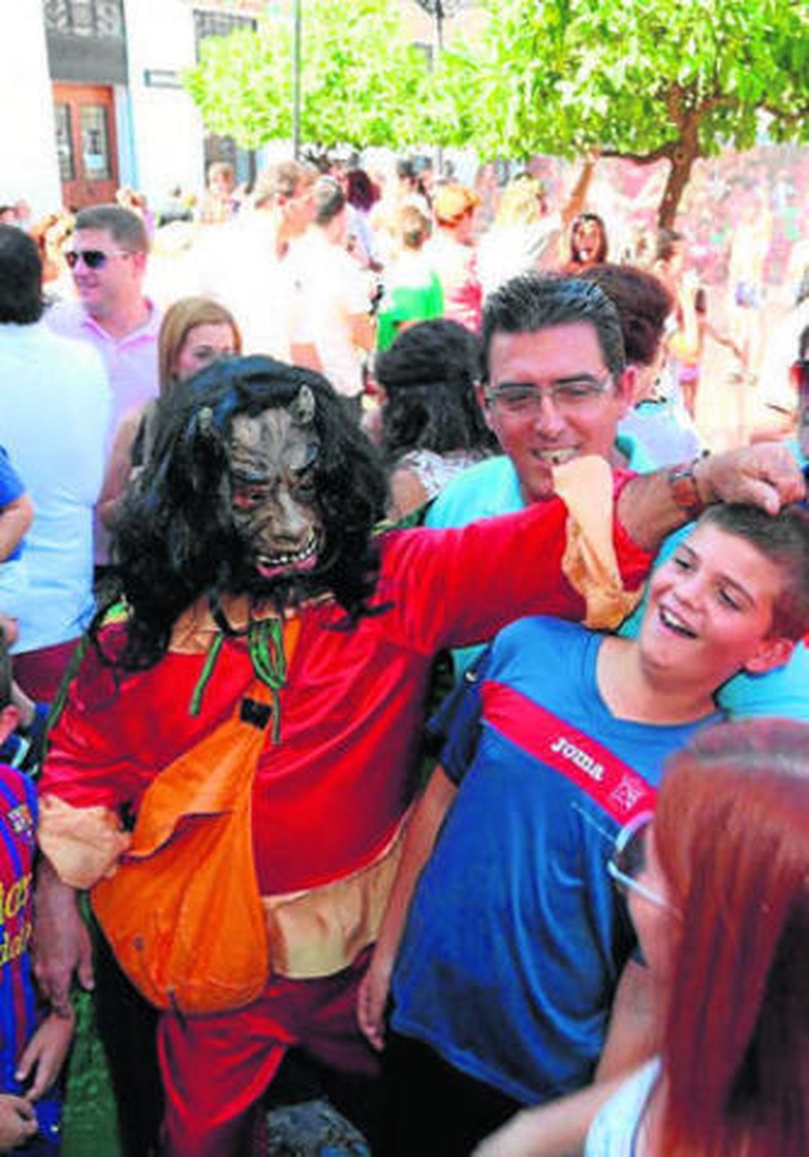 La diablilla juega con un niño durante la fiesta de San Bartolomé.