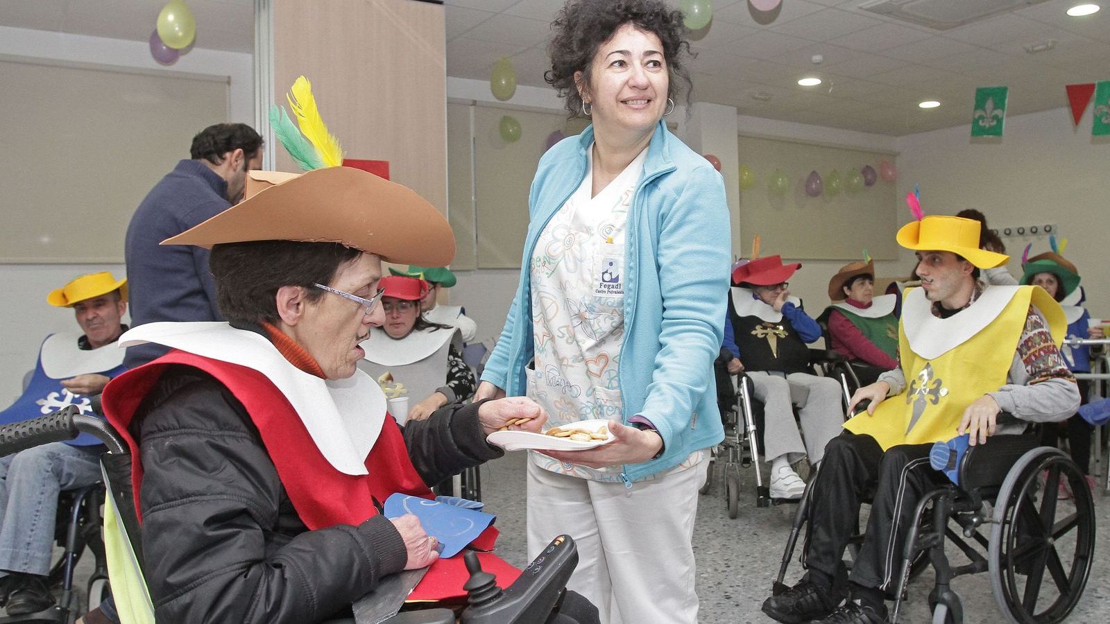 Una cuidadora acompaña a un residente en un taller ocupacional en el Centro de Día de La Línea.