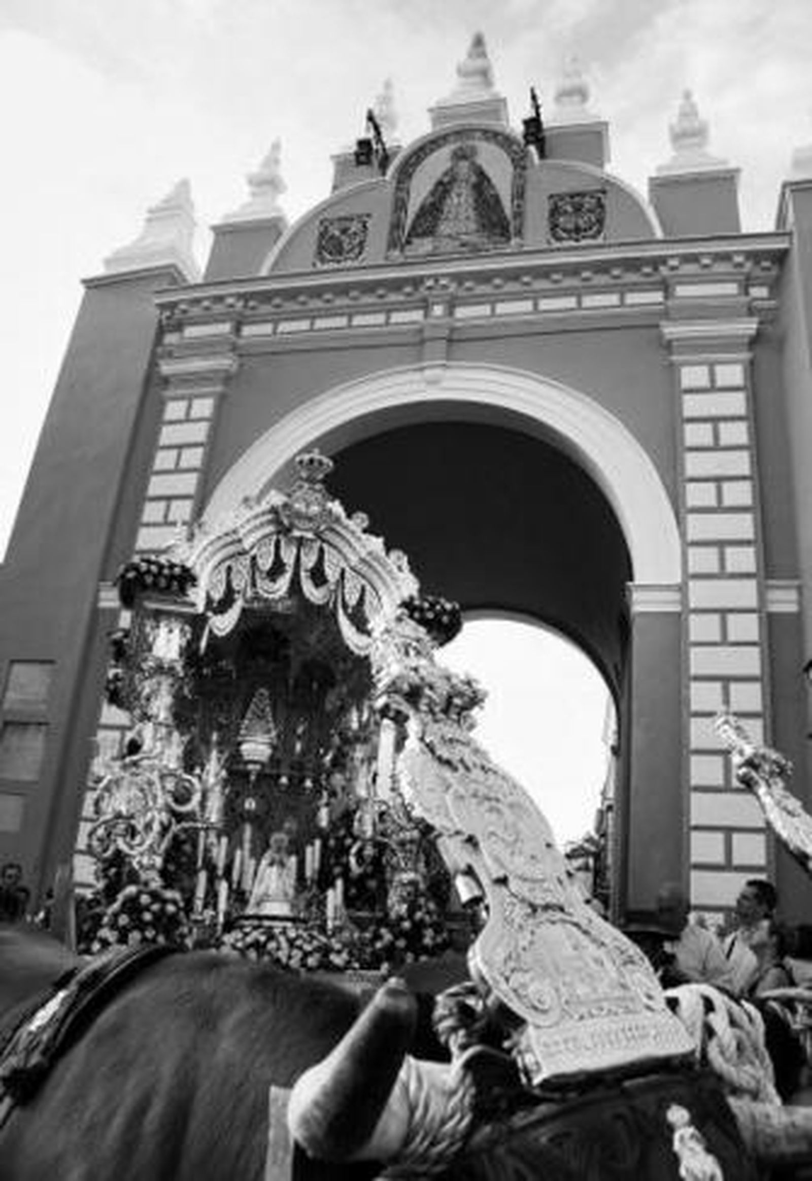 1. El arco es la puerta por antonomasia de la macarena: de Extramuros  a San Luis. Puerta del cielo en la Madrugada y portada del paraíso en esta vuelta de tuerca del calendario rociero. En primer plano, el poderío tartésico de la testuz de los bueyes. 2. Los rocieron abandonan el barrio tras la misa de romeros en la iglesia de San Gil y anunciaron primero con campanas, después con cohetes, el inicio de la romería. 3. El alcalde de carretas de Macarena, Marcelino Vázquez, este año sin el contratiempo de las elecciones municipales, llevaba el timón de la nave rociera desde su salida. De fondo, la Basílica de la Macarena, punto de partida del camino.