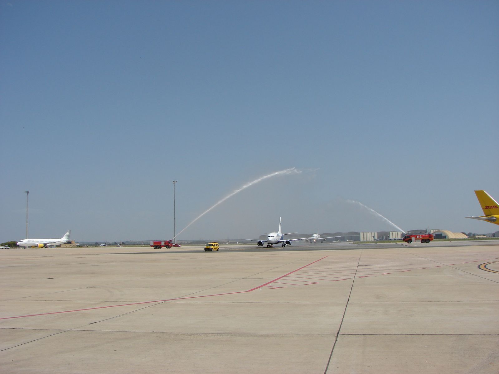 Dos camiones de bomberos reciben con un arco de agua al avión.