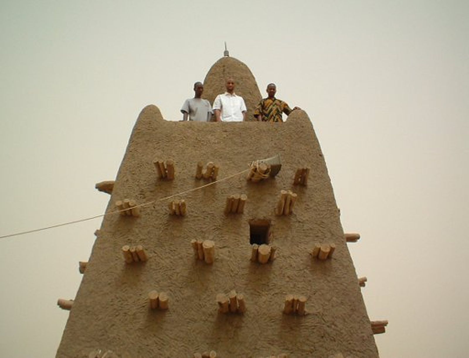 Con camisa blanca, encaramado a una de las torres de la mezquita de Djingareyber, Tombuctú.