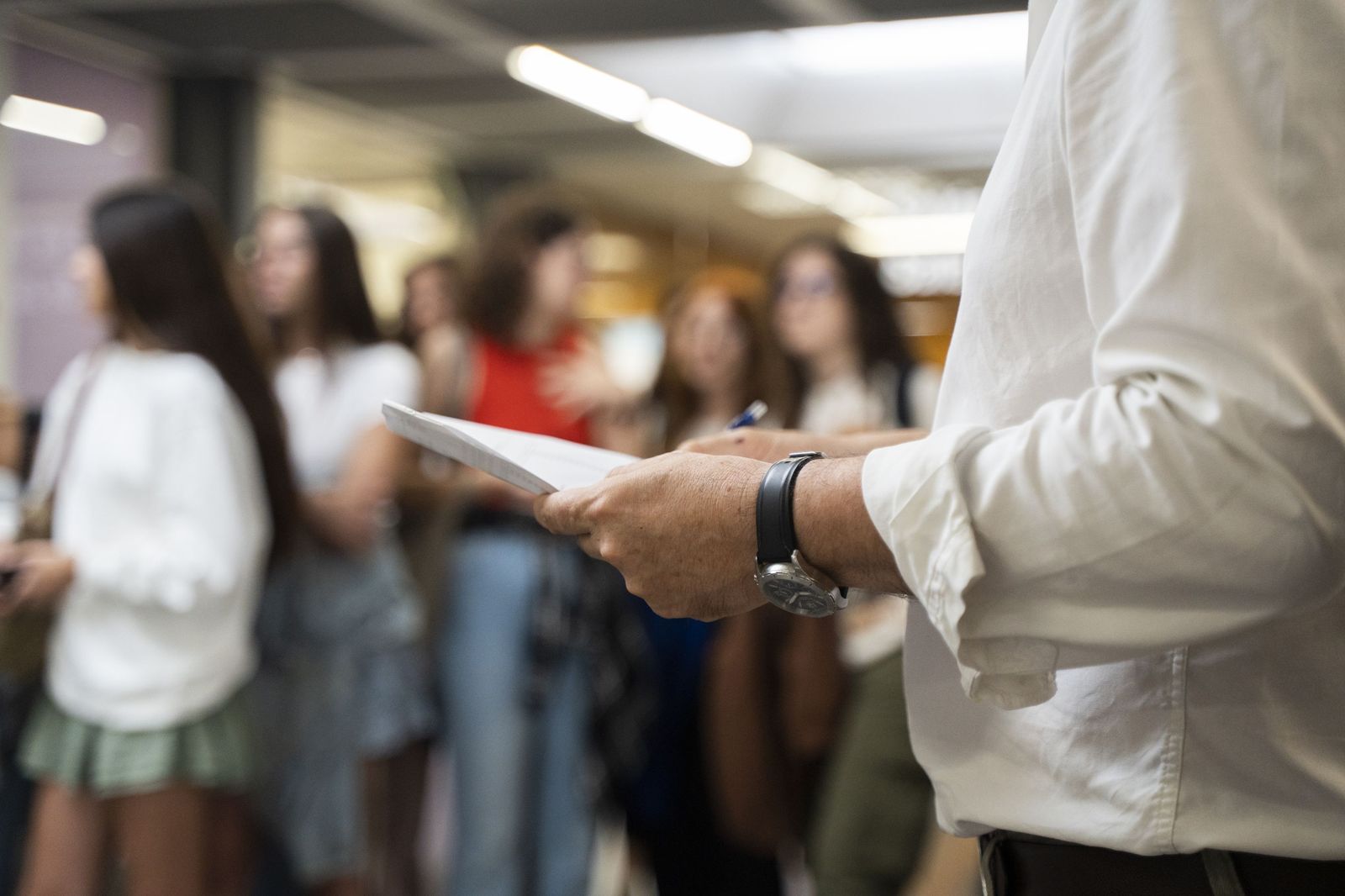 Un profesor sujeta una pila de exámenes