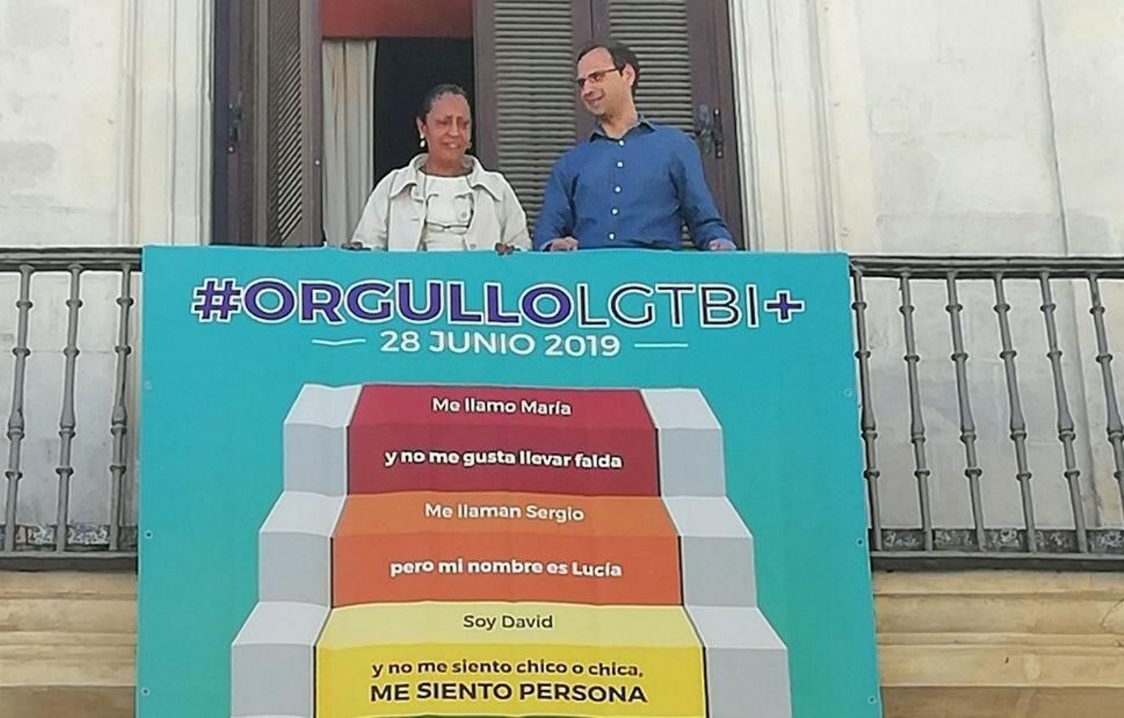 El alcalde y la concejala gobernante Teresa Rúa colocando esta mañana una pancarta en el balcón de la Biblioteca Municipal.