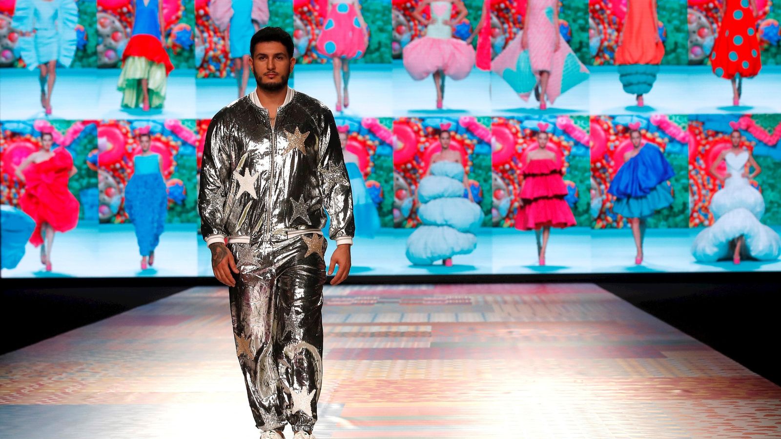 El cantante Omar Montes desfila en Madrid con un conjunto de sudadera y pantalón plateados de Ágatha Ruíz de la Prada.