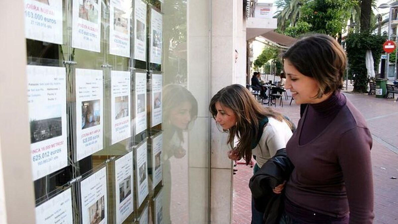 Dos jóvenes, ante una inmobiliaria. Dos jóvenes, ante una inmobiliaria.