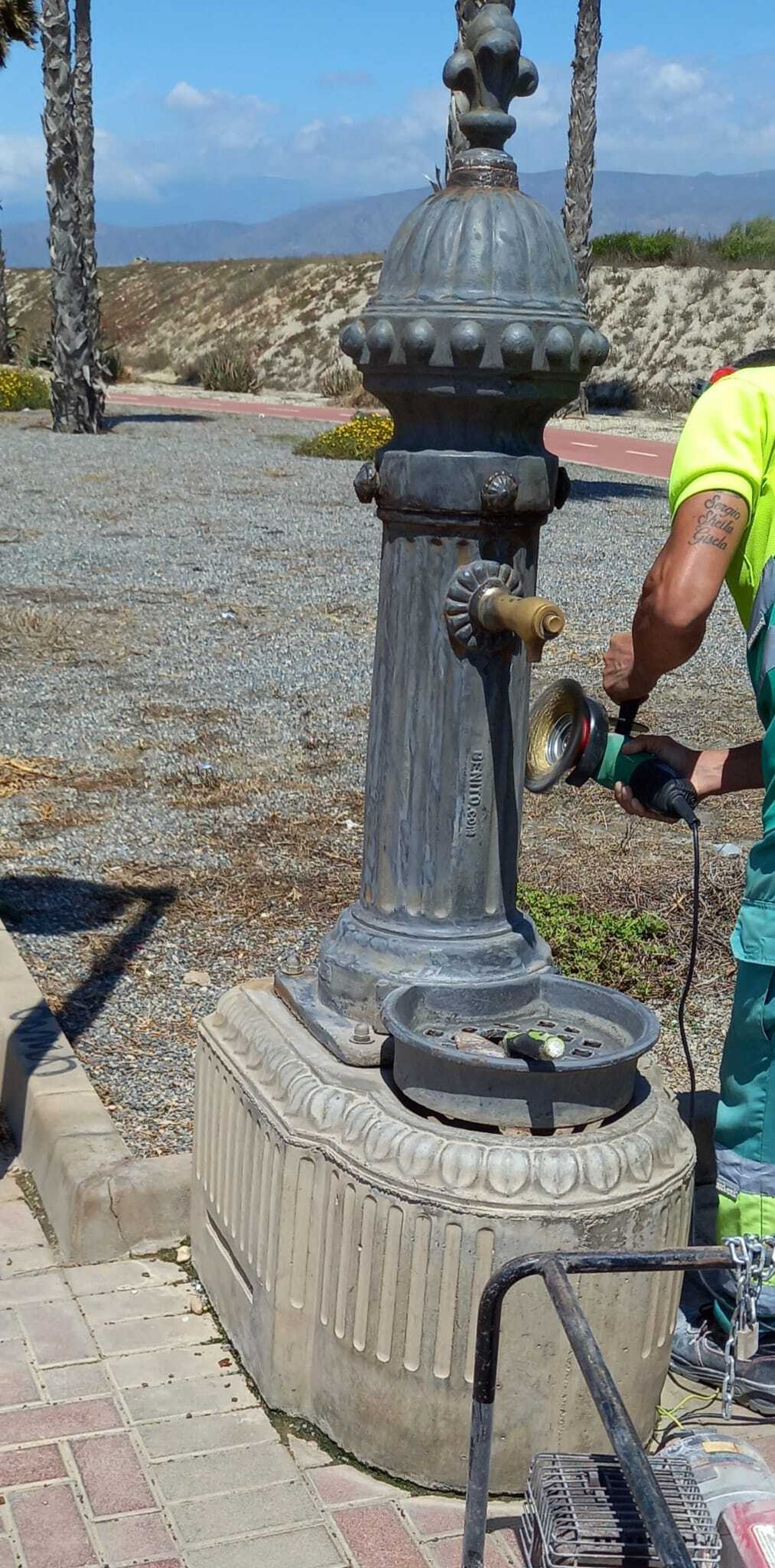 Un operario repara una de las fuentes bebedero  de la capital