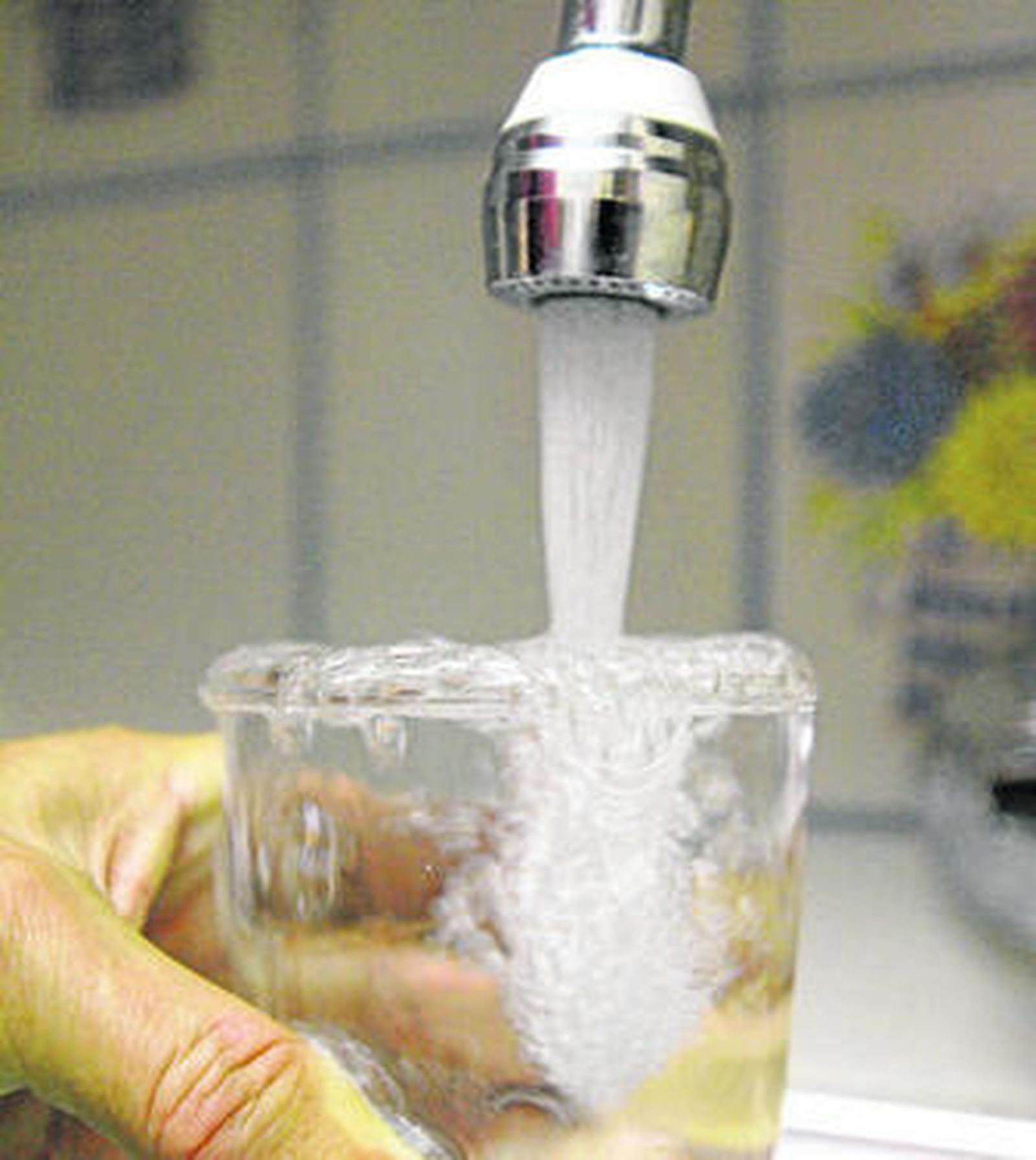 Grifo abierto para llenar un vaso de agua.