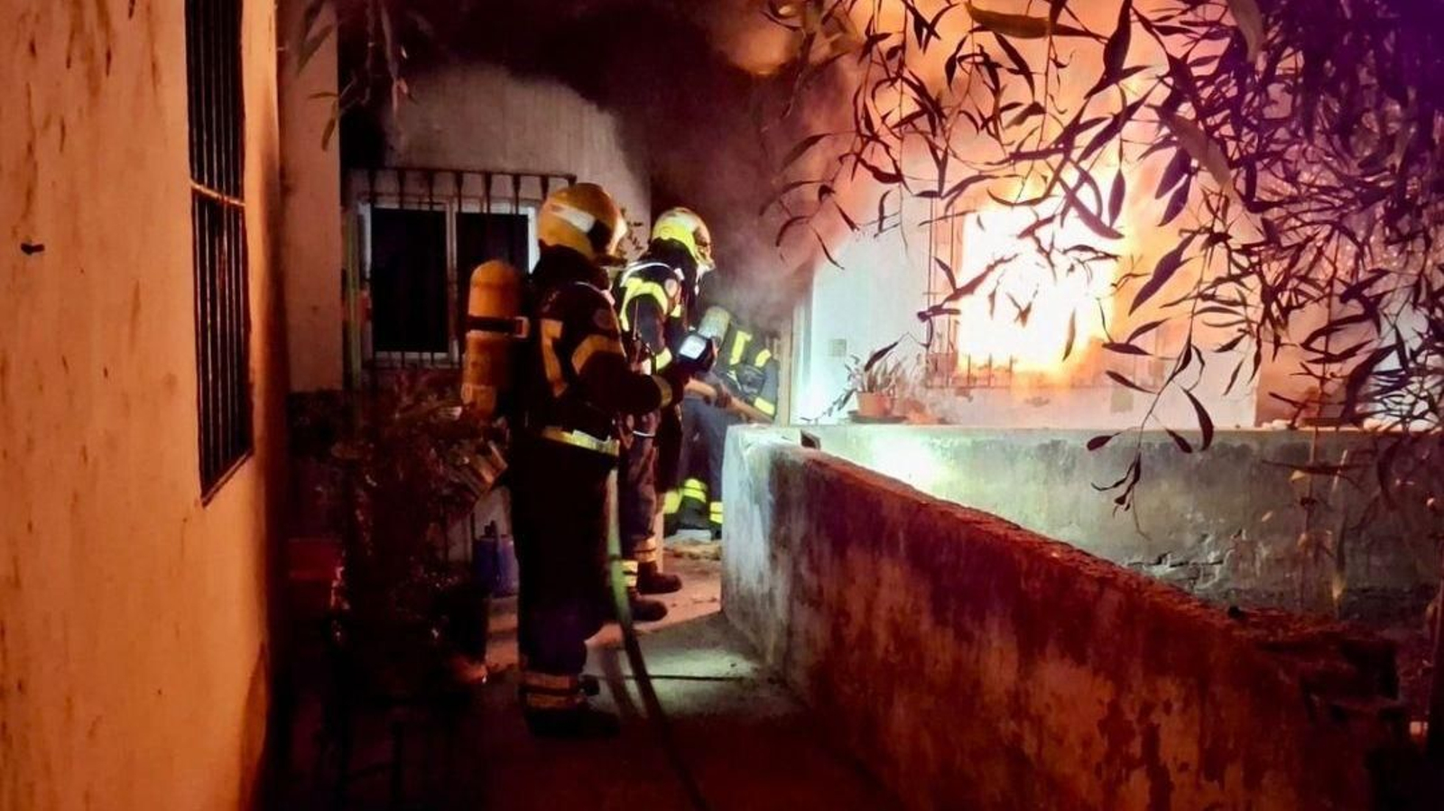 Bomberos en la vivienda afectada por el fuego en la zona de La Granja en Jerez.