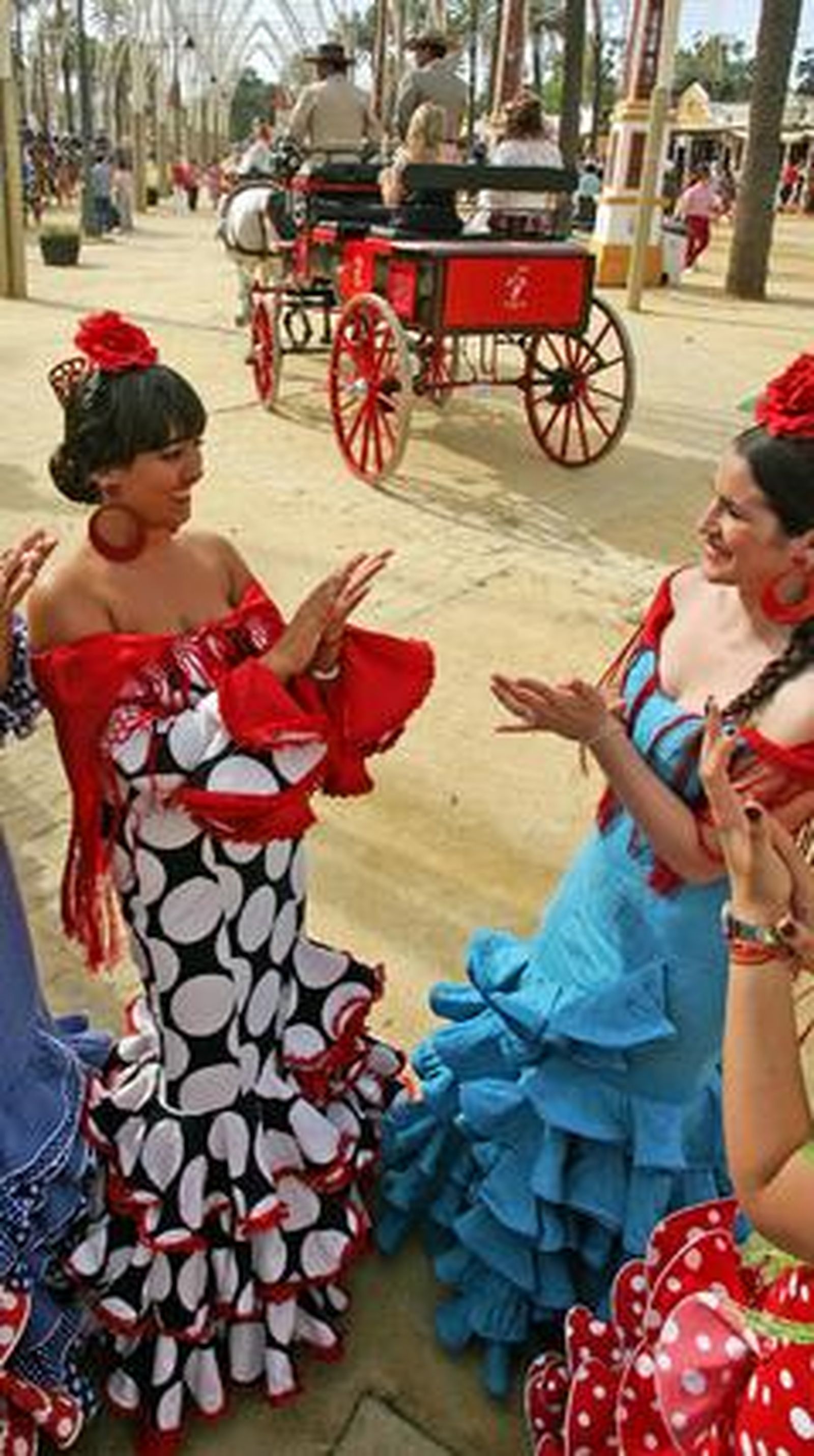 Dos mujeres vestidas de gitana se divierten tocando las palmas mientras pasa un enganche ayer en el parque González Hontoria.

Foto: Pascual