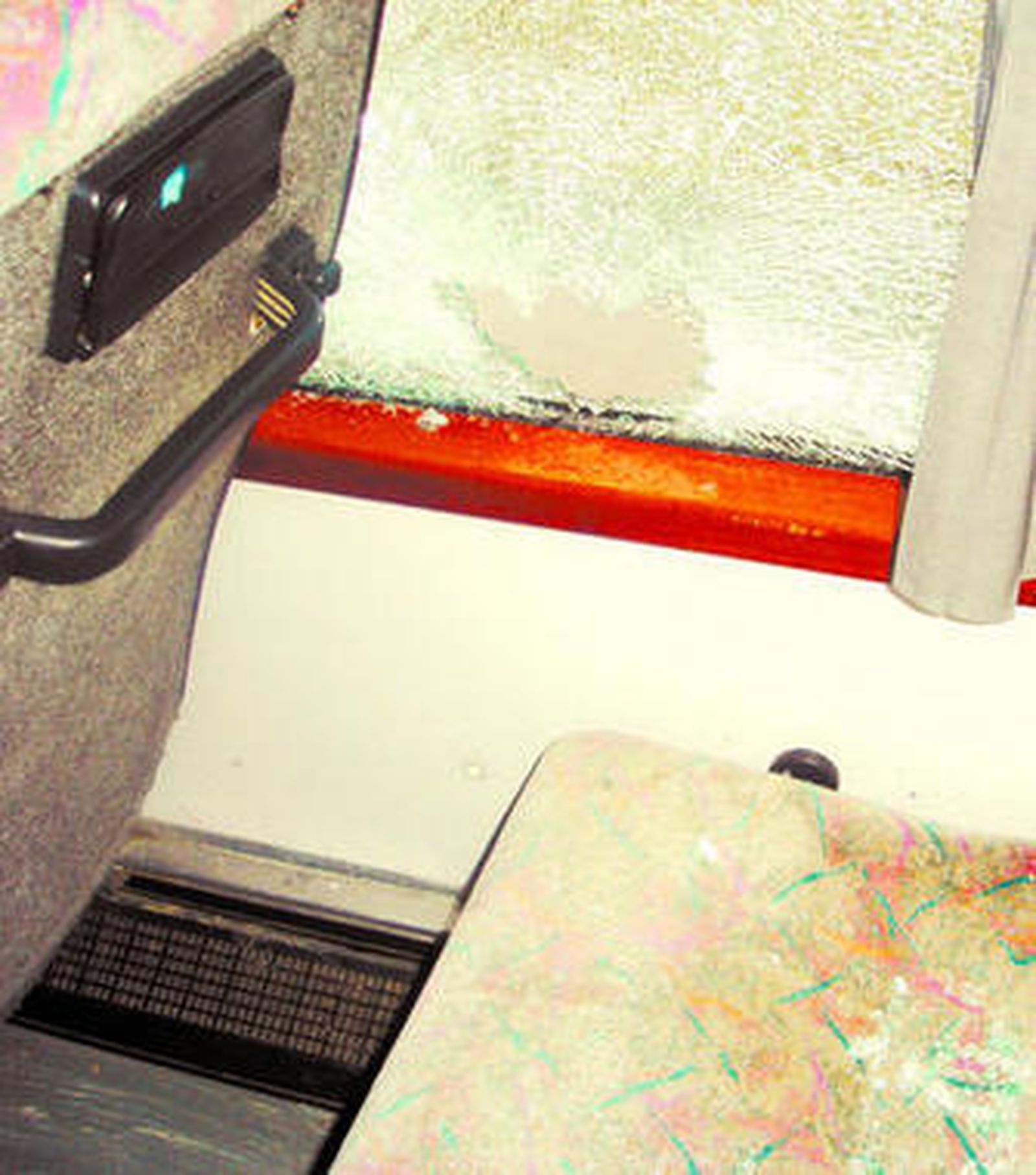 Primer plano de los cristales del autobús destrozados a pedradas.